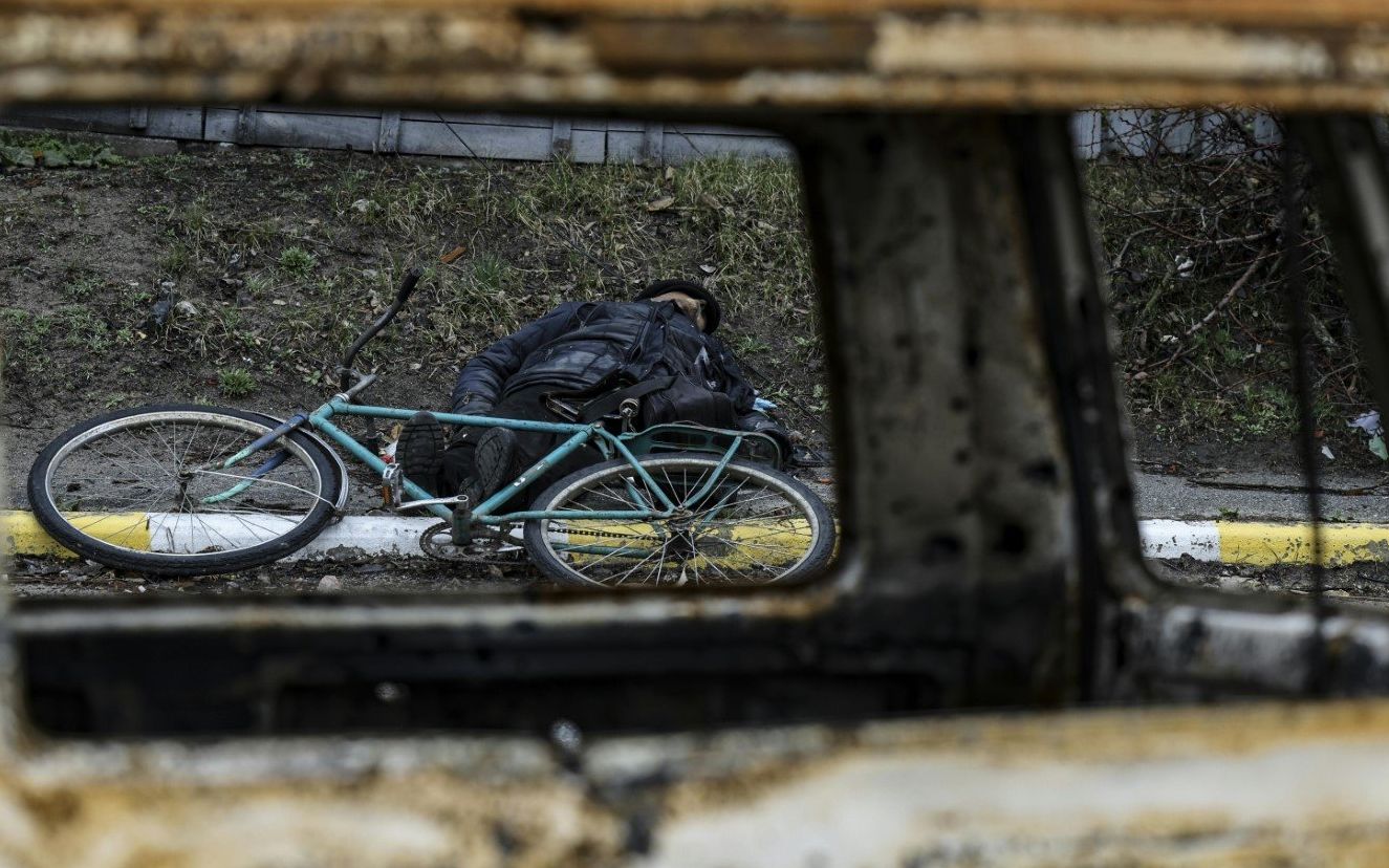 EDITORS NOTE: Graphic content / A dead body lies on the ground in a street in Bucha, northwest of Kyiv, as Ukraine says Russian forces are making a "rapid retreat" from northern areas around Kyiv and the city of Chernigiv, on April 2, 2022. - The bodies of at least 20 men in civilian clothes were found lying in a single street Saturday after Ukrainian forces retook the town of Bucha near Kyiv from Russian troops, AFP journalists said. Russian forces withdrew from several towns near Kyiv in recent days after Moscow's bid to encircle the capital failed, with Ukraine declaring that Bucha had been "liberated". (Photo by RONALDO SCHEMIDT / AFP)