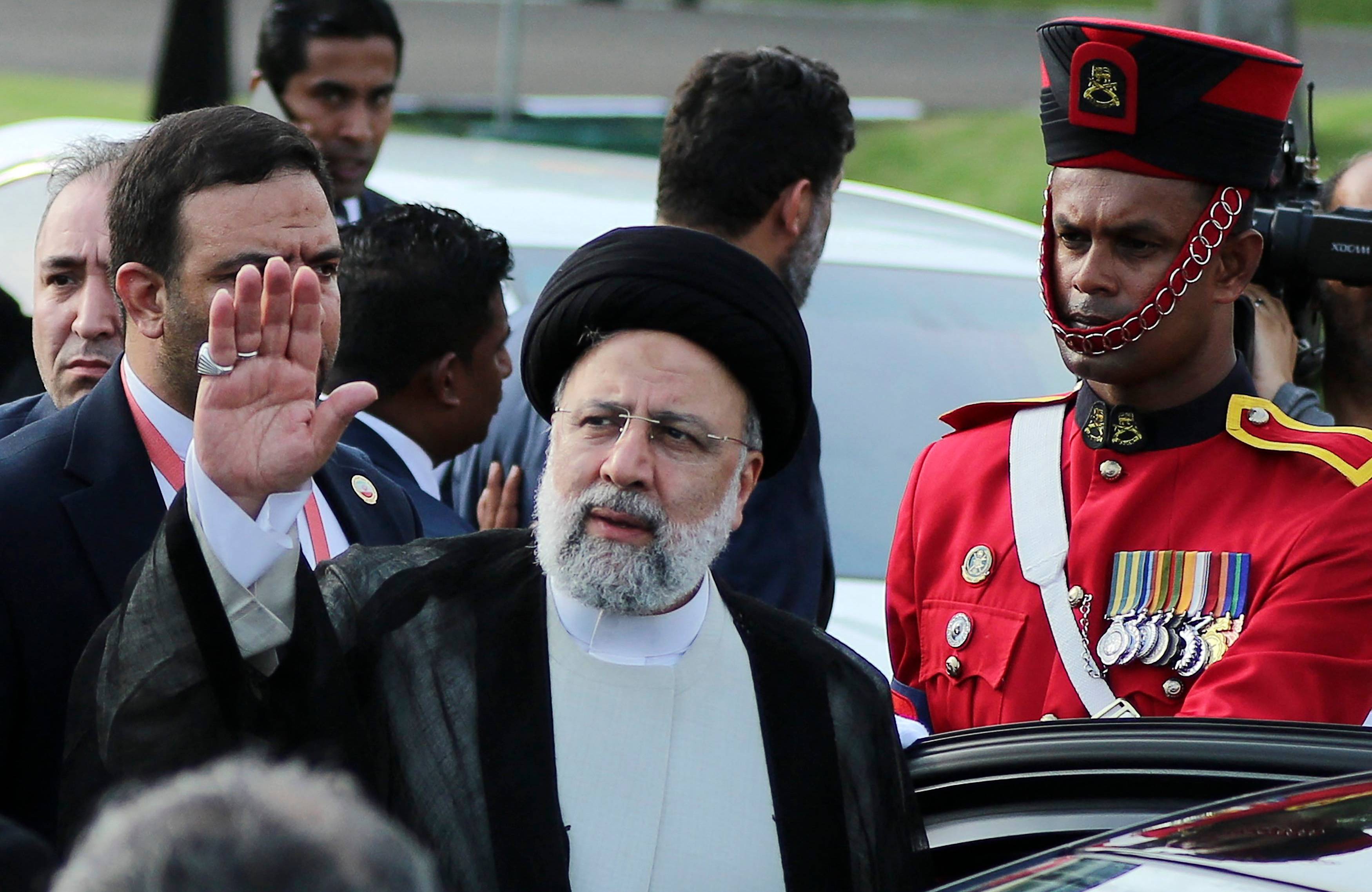 Prezydent Iranu podnosi dłoń w geście powitania