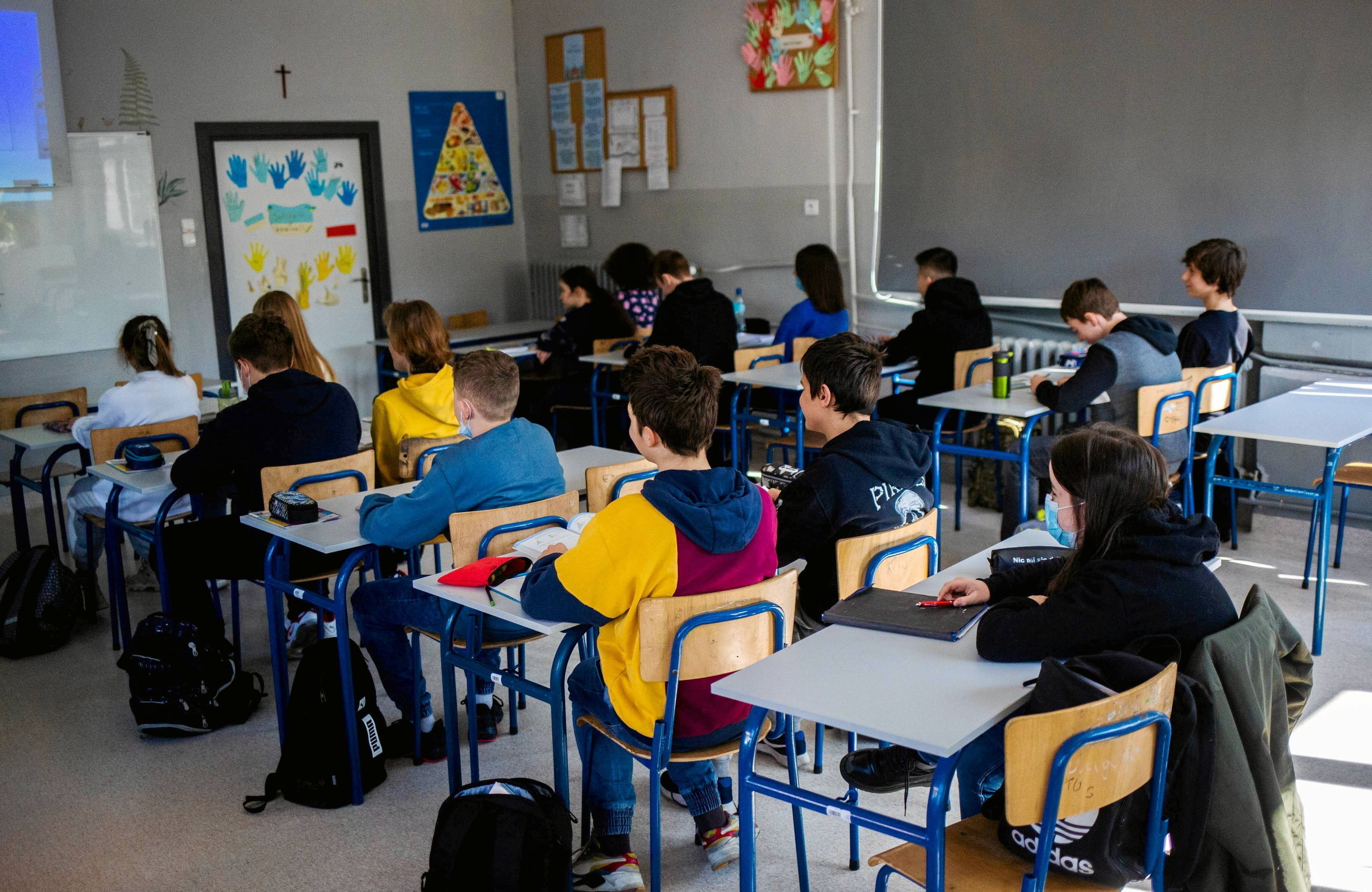 Na zdjęciu jest klasa szkolna. Nastolatki siedzą za ławkami