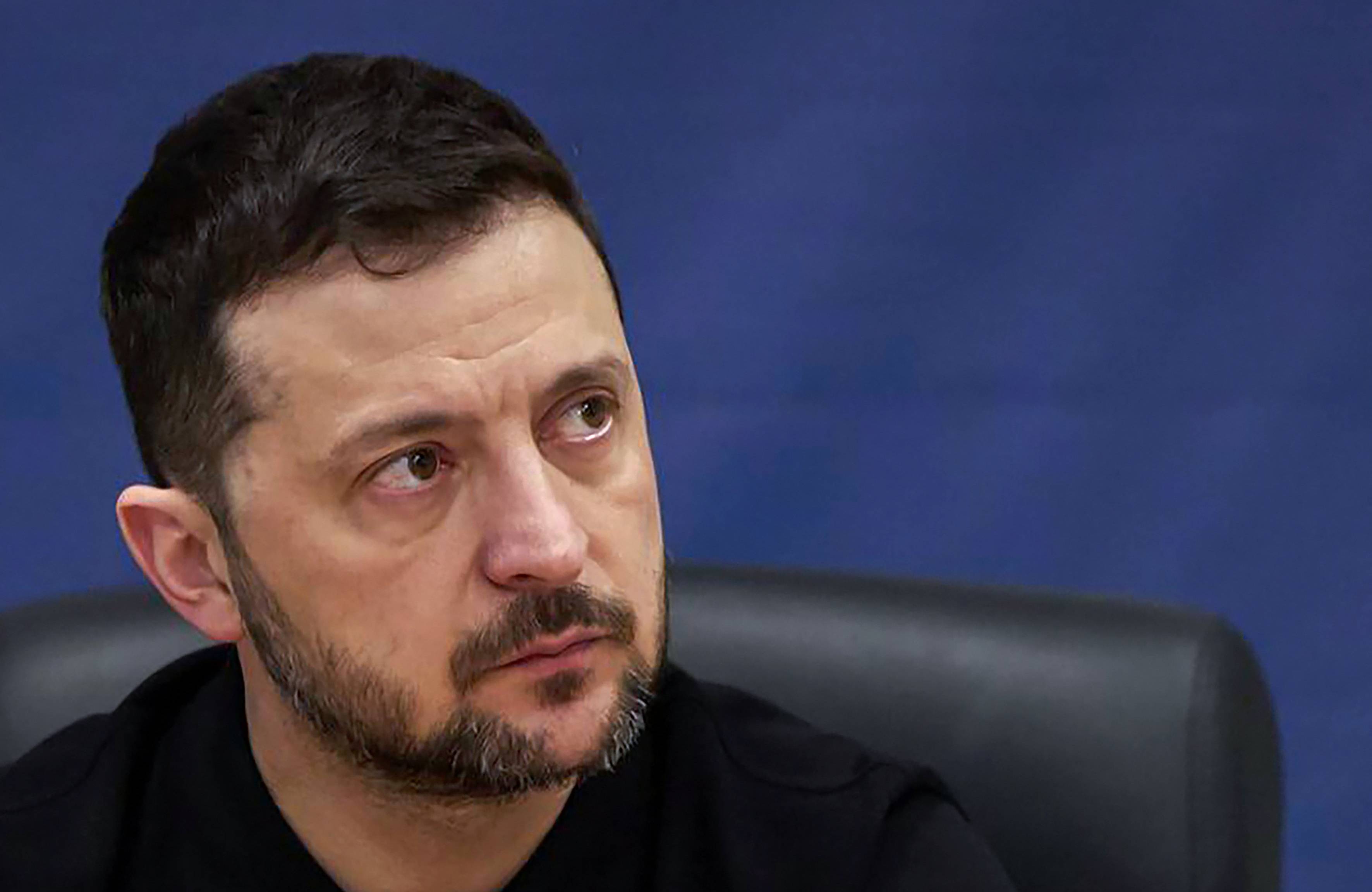 Mężczyzna w średnim wieku z zarostem (prezydent Ukrainy Wołodymyr Zełenski) na granatowym tle