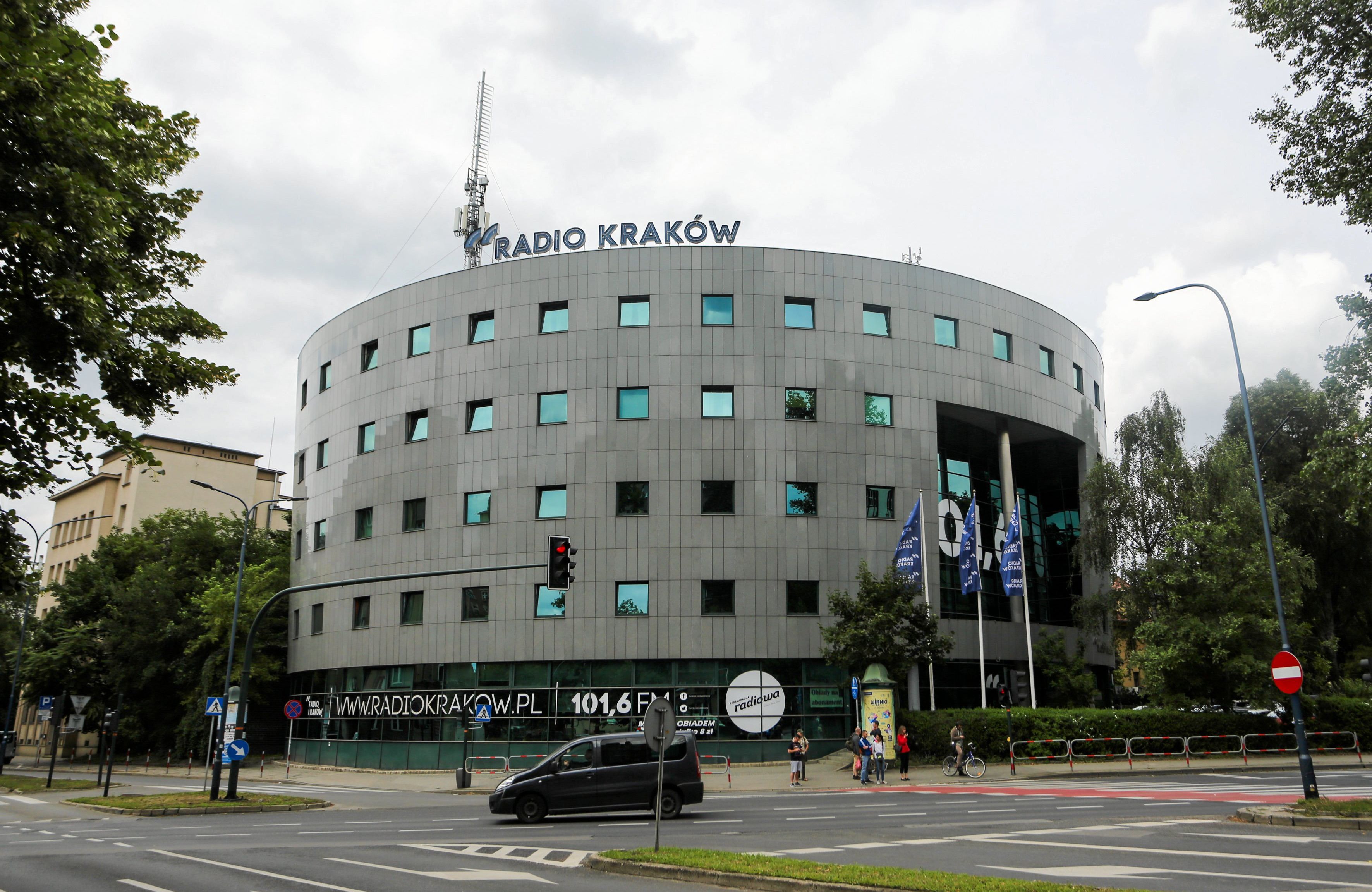 nowoczesny budynek Radia Kraków, zbudowany na planie półkola, z dużymi przeszkleniami, na szczycie logo i napis "radio kraków"