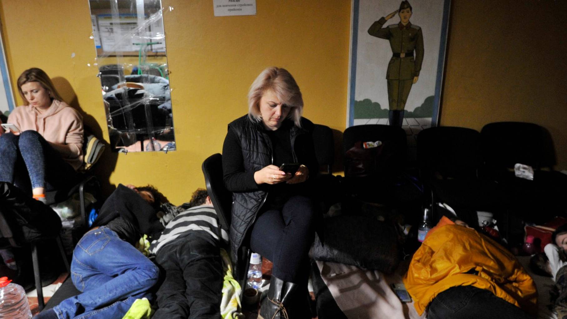 Ukraina. Kobieta siedzi na pryczy, chroniąc się przed rosyjskim bombardowaniem w schronie w Kijowie