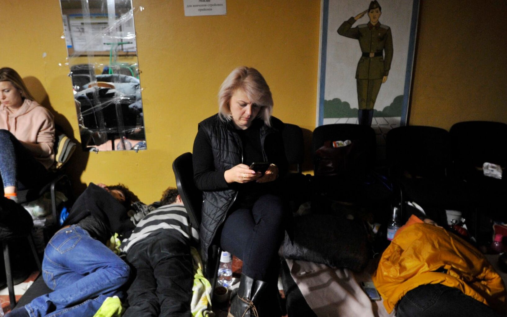 People hide in a bomb shelter in Kyiv in the early hours of February 25, 2022. - Invading Russian forces pressed deep into Ukraine as deadly battles reached the outskirts of Kyiv, with explosions heard in the capital early Friday that the besieged government described as "horrific rocket strikes". The blasts in Kyiv set off a second day of violence after Russian President Vladimir Putin defied Western warnings to unleash a full-scale ground invasion and air assault that quickly claimed dozens of lives and displaced at least 100,000 people. (Photo by Sergei CHUZAVKOV / AFP)