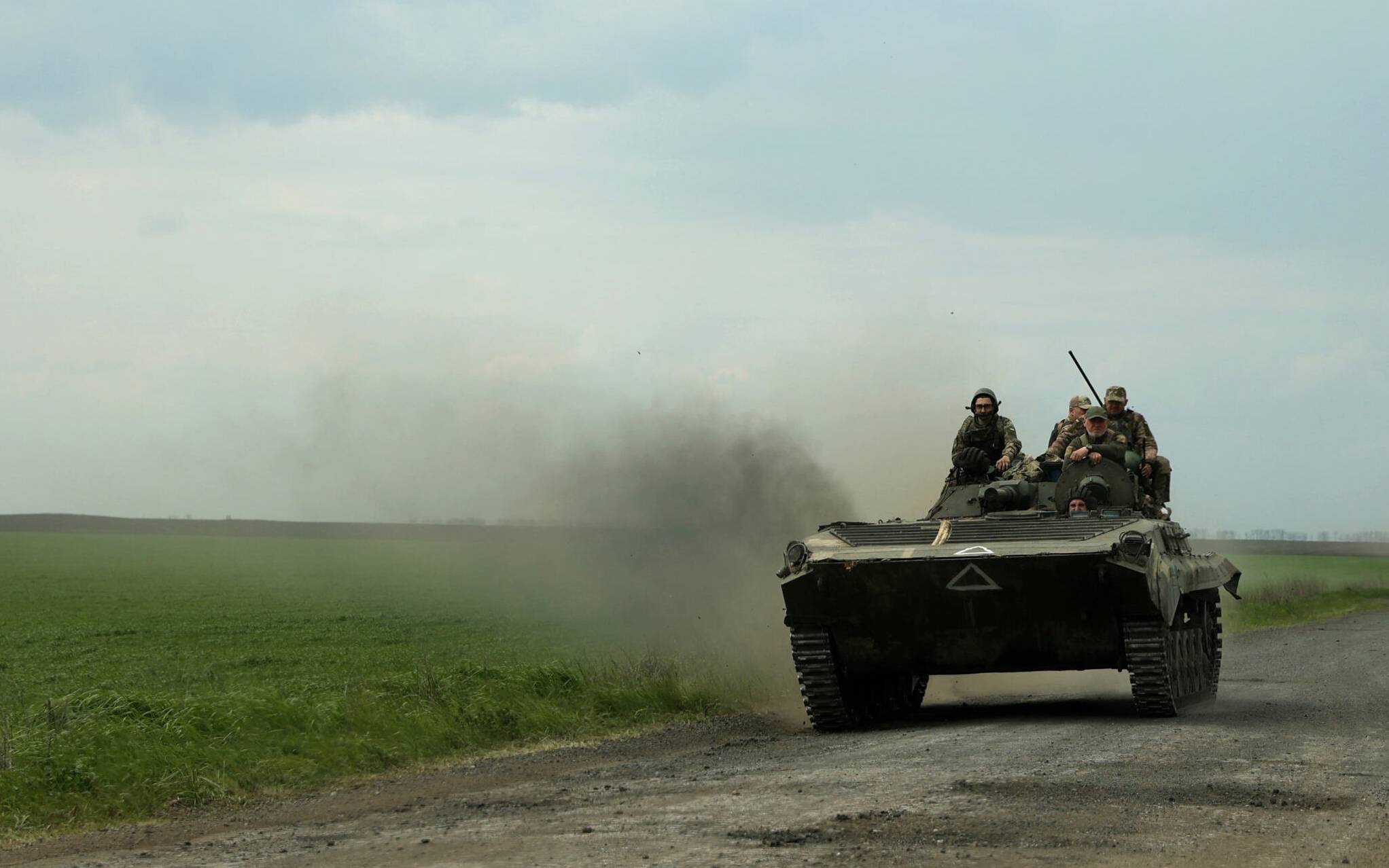 Ukrainian servicemen ride on an armored personnel carrier (APC) on a road near Petrivske village, in Kharkiv region, amid the Russian invasion of Ukraine, on May 9, 2022. (Photo by Anatolii Stepanov / AFP)
