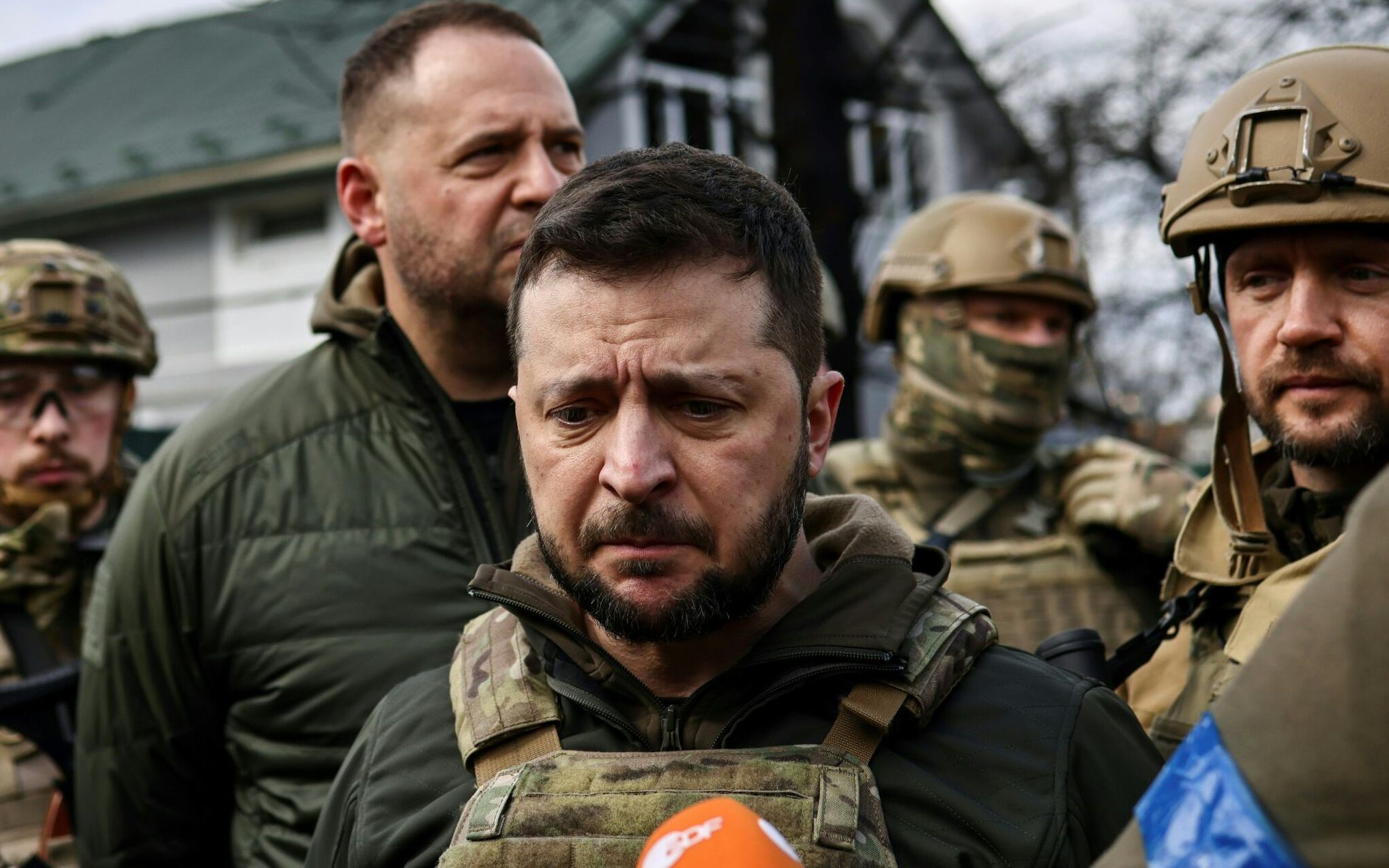 Ukainian President Volodymyr Zelensky (C) speaks to the press in the town of Bucha, northwest of the Ukrainian capital Kyiv, on April 4, 2022. - Ukraine's President Volodymyr Zelensky said on April 3, 2022 the Russian leadership was responsible for civilian killings in Bucha, outside Kyiv, where bodies were found lying in the street after the town was retaken by the Ukrainian army. (Photo by RONALDO SCHEMIDT / AFP)