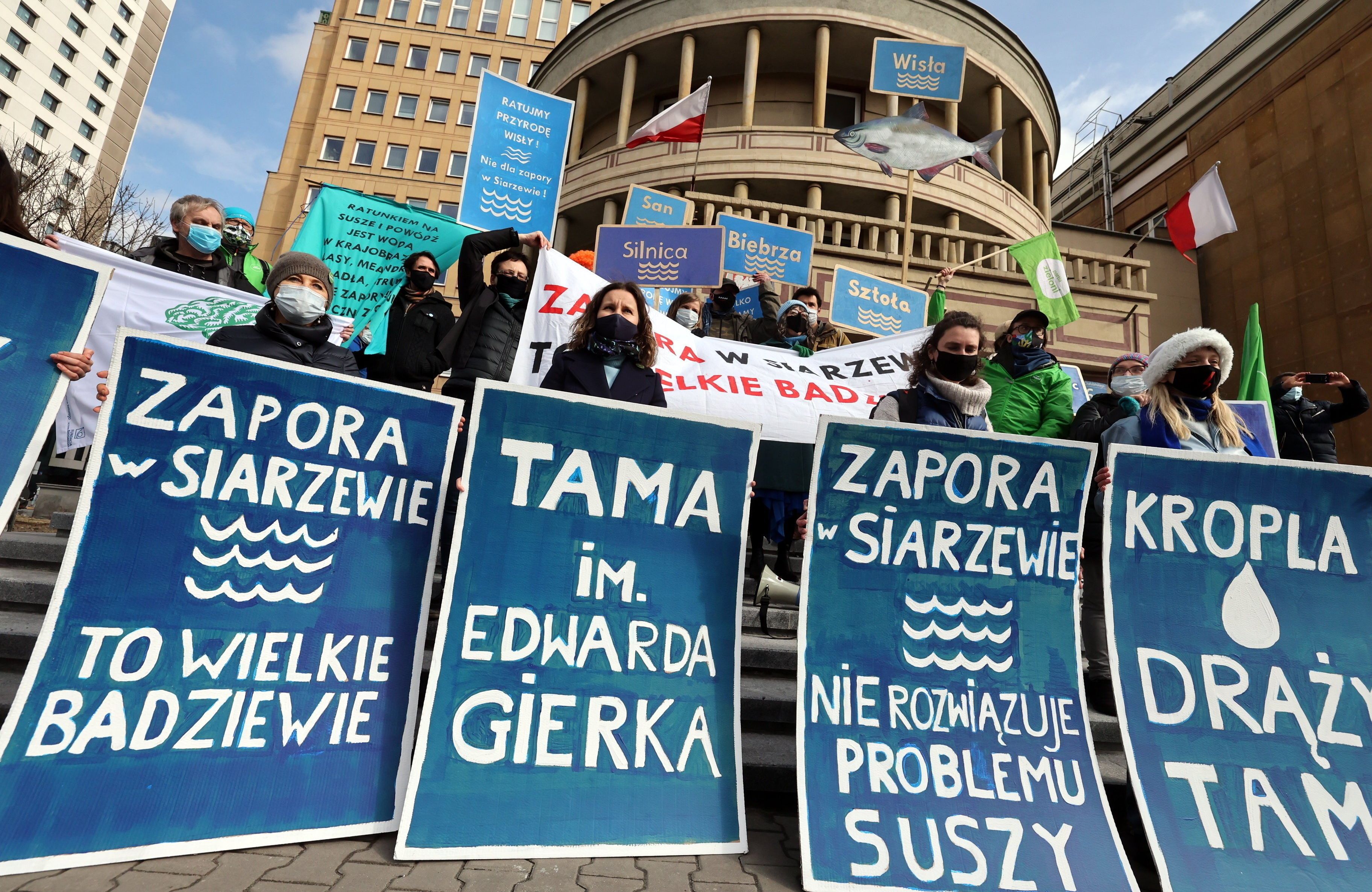 protest, osoby w maskach mają banery z napisami zapora w siarzewie nie rozwiązuje problemu suszy i tama im. gierka