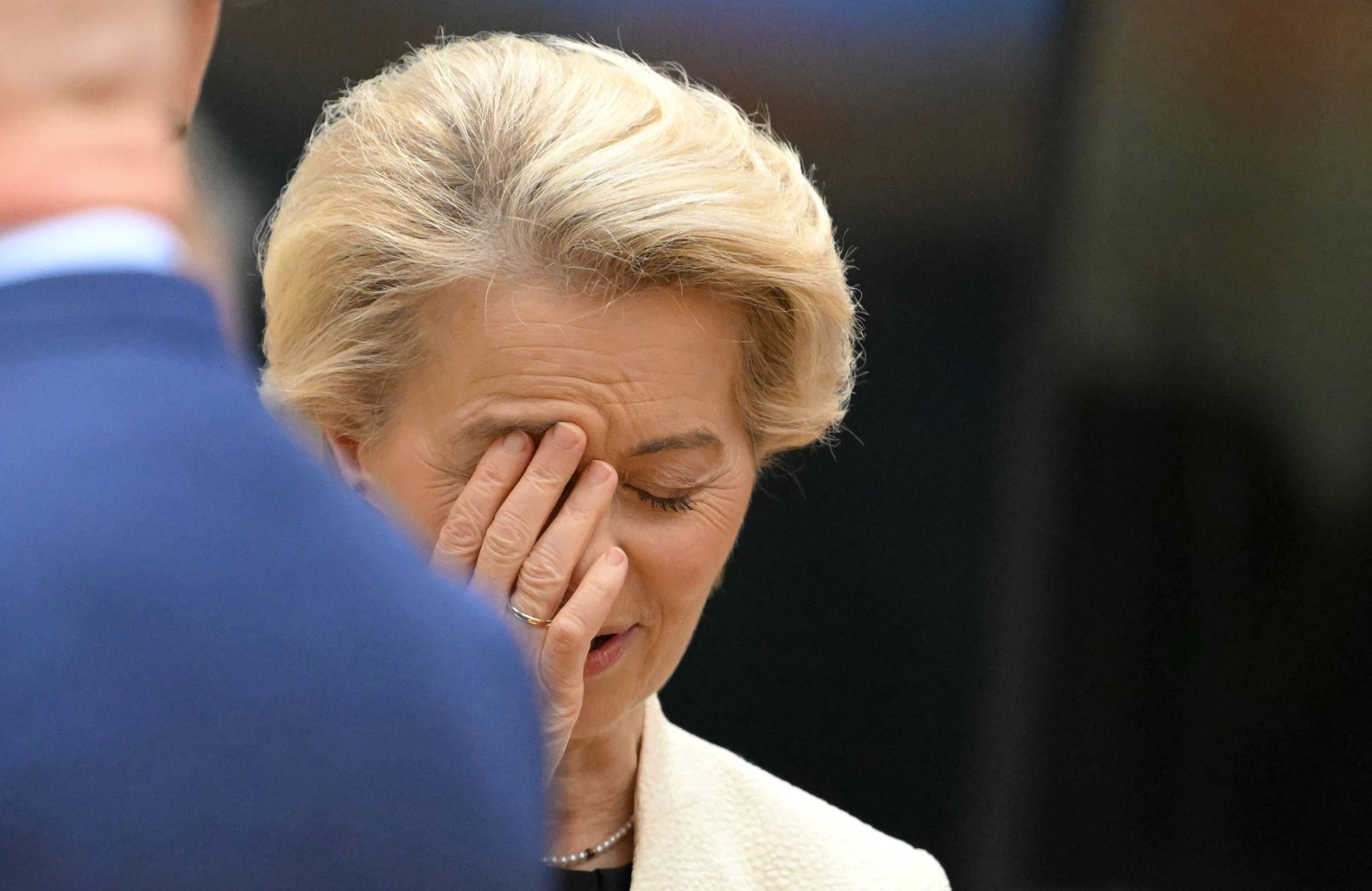 Kobieta zakrywa twarz dłonią. Ursula von der Leyen