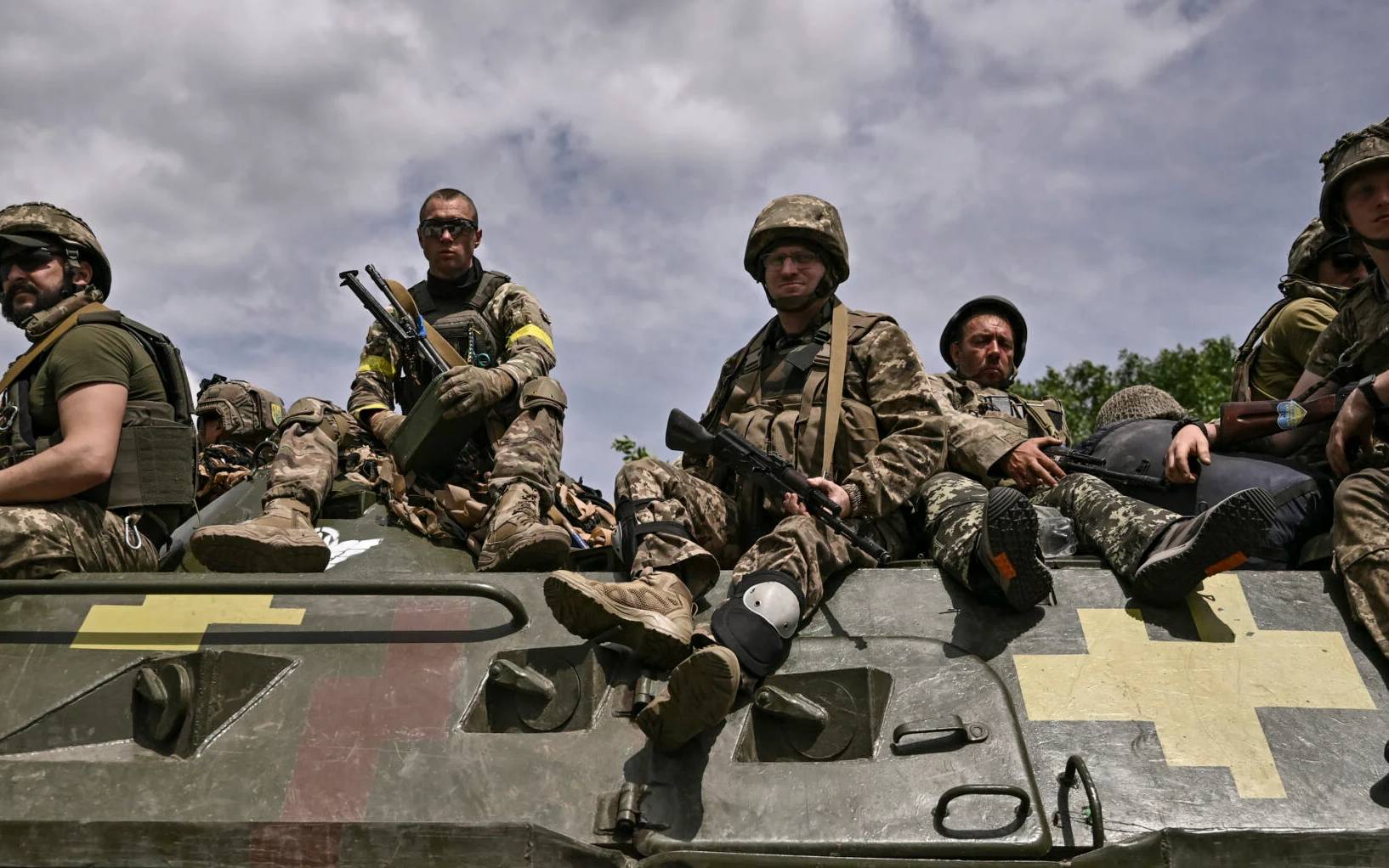 Ukrainian troops sit on an armoured vehicle as they move back from the front line near the city of Sloviansk in the eastern Ukrainian region of Donbas on June 1, 2022. (Photo by ARIS MESSINIS / AFP)