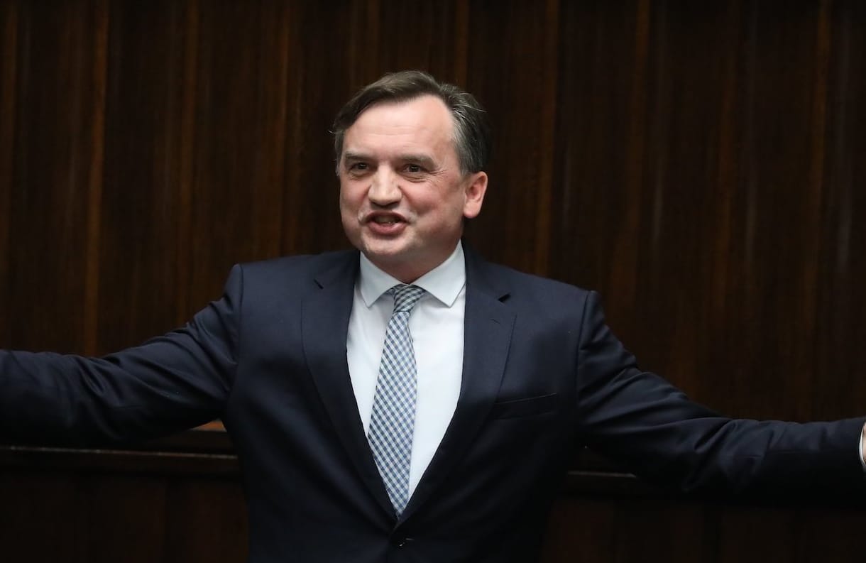 Minister Ziobro przemawia z sejmowej mównicy i szeroko rozkłada ręce