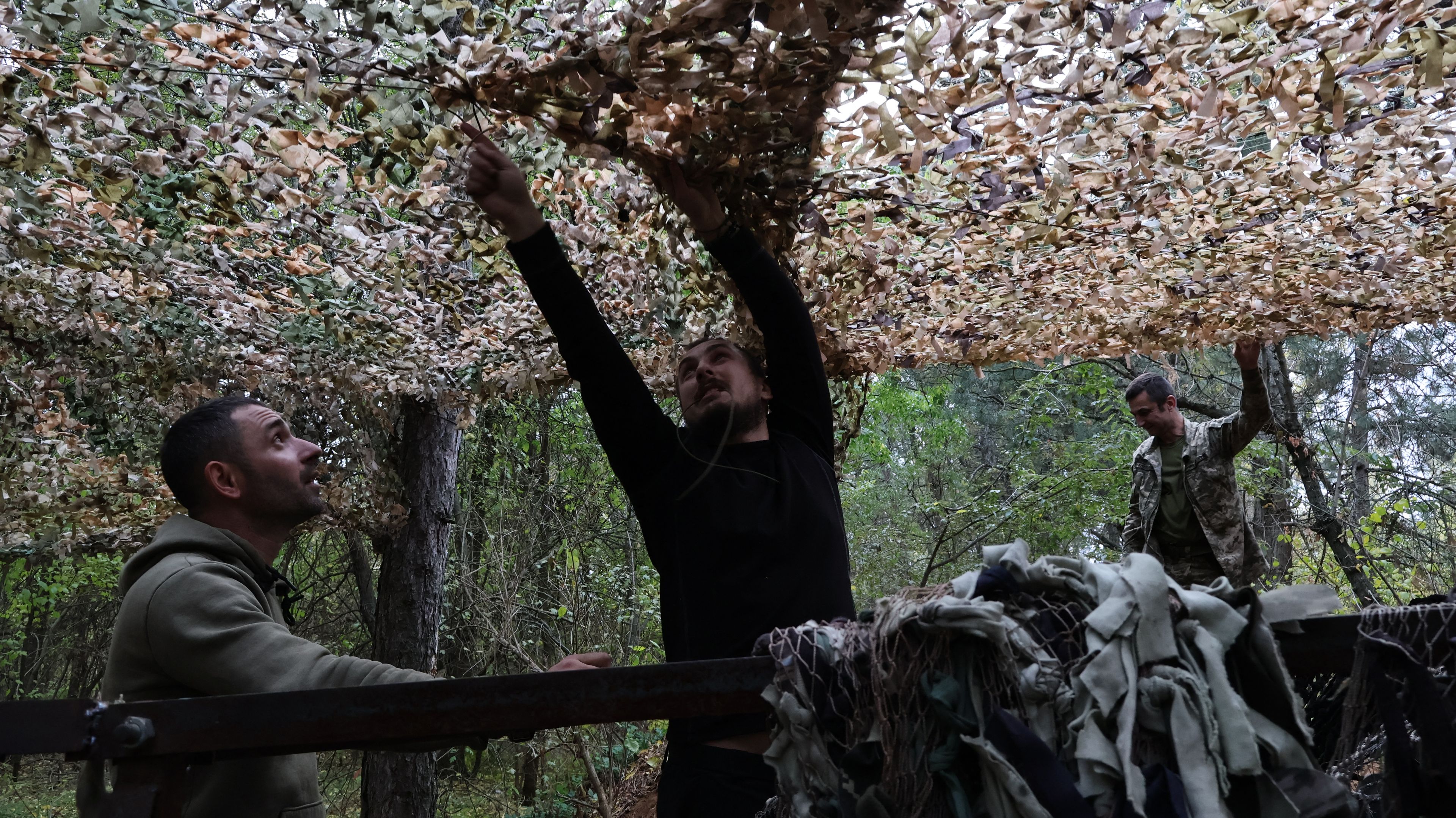 Mężczyźni montujący siatkę maskującą.