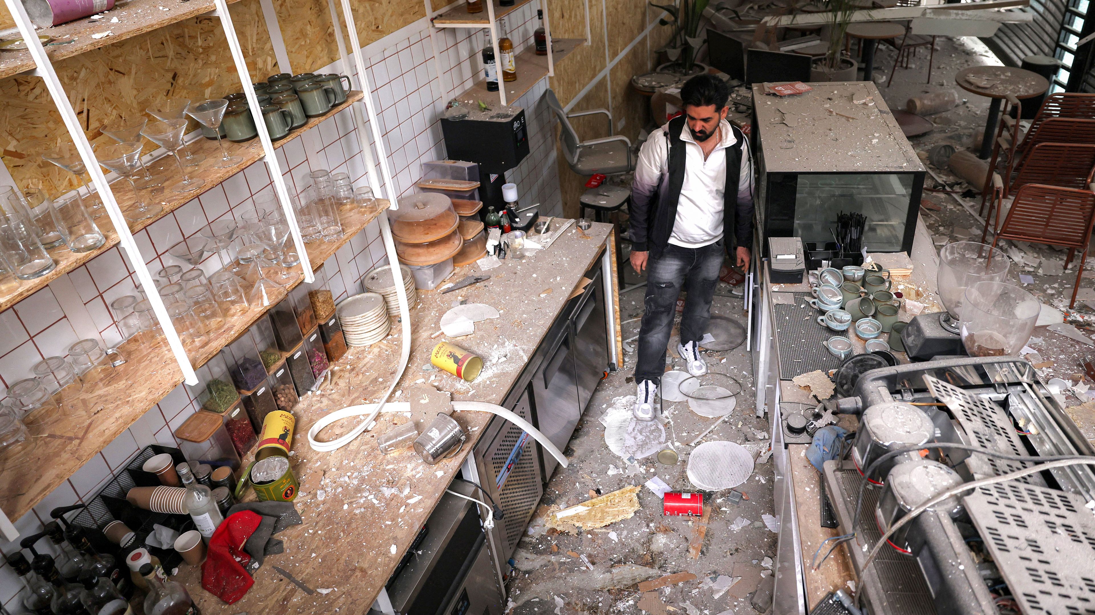 Cafe staff inspect the destruction at the premises following a missile strike on their building earlier in the day in Tehran on March 29, 2026. Doha-headquartered news network Al Araby TV on March 29 criticised a strike on the building hosting its Tehran office, as Israel and the US pressed an aerial campaign against Iran. (Photo by ATTA KENARE / AFP) /