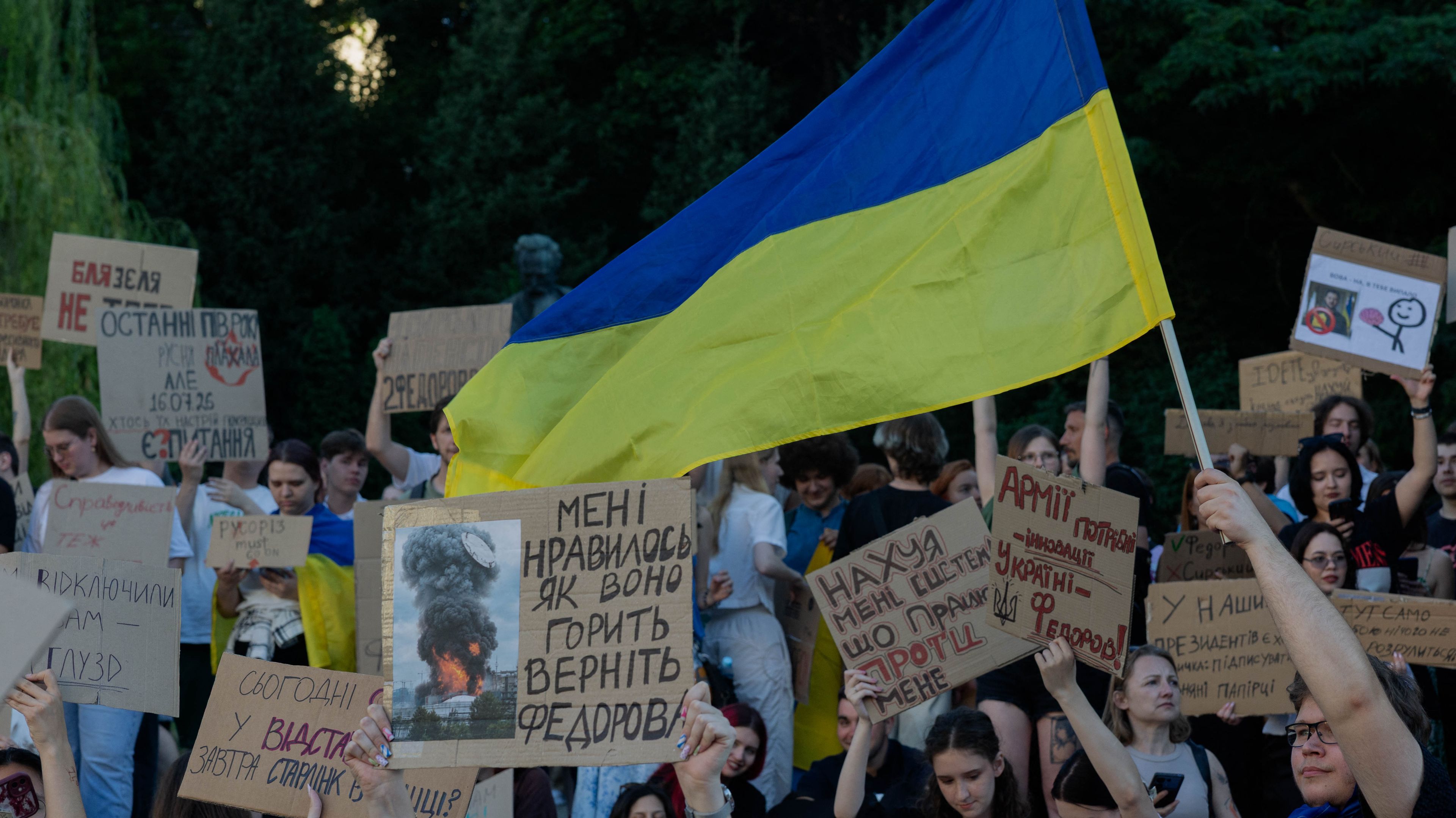 Na zdjęciu jest tłum ludzi z transparentami, widać też flagę niebiesko-żółtą