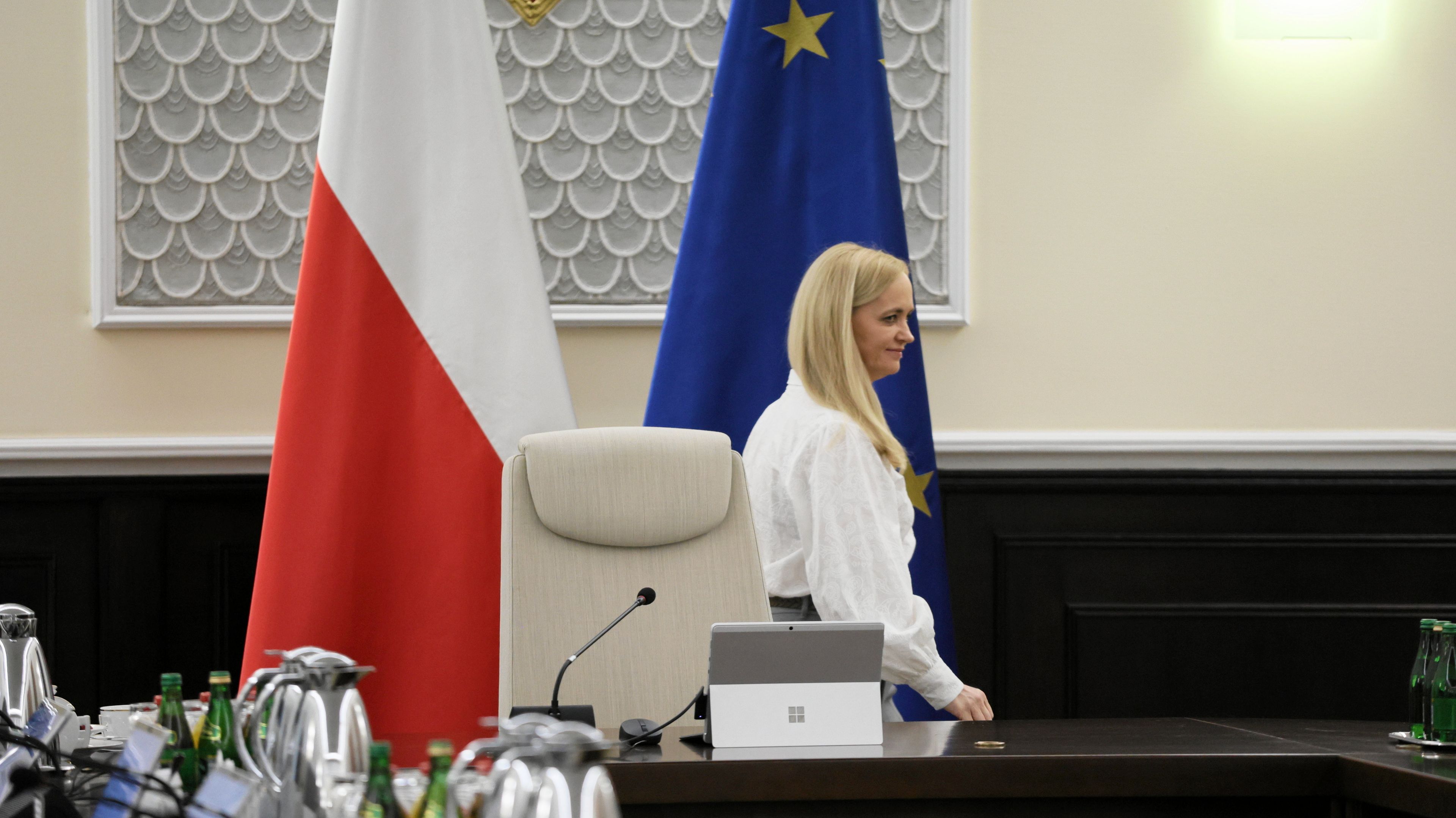 Samtna kobieta w białym żakiecie na sali posiedzeń rządu
