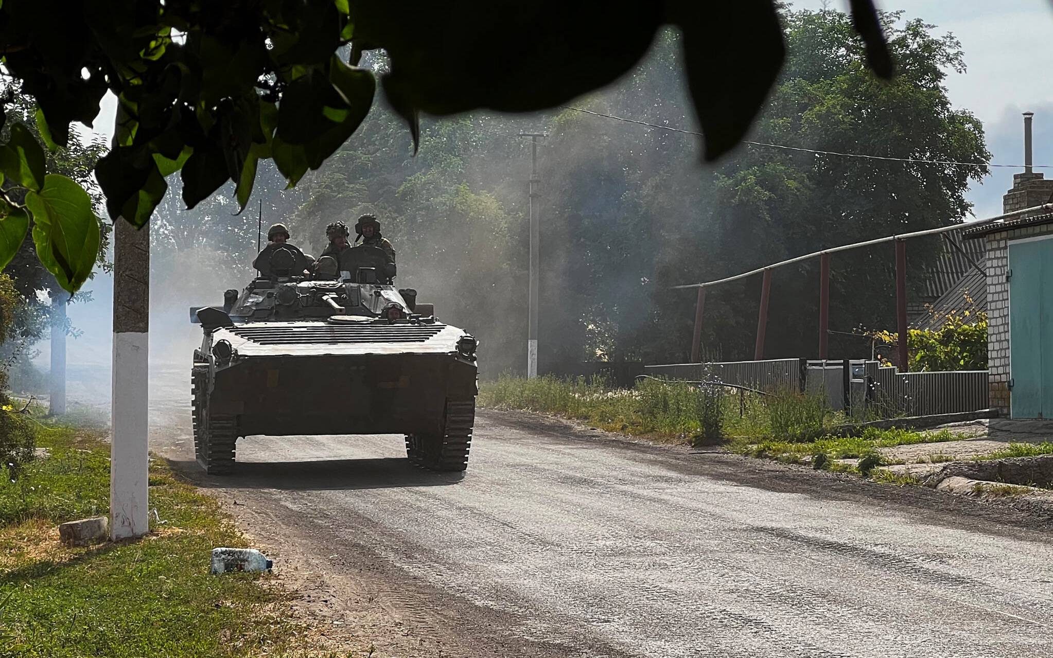 Ukrainian soldiers ride an armoured vehicle on the main road to Lysychansk in Ukraines eastern region of Donbas on June 26, 2022. - Russian forces achieved major military successes in eastern Ukraine on June 25, 2022, fully capturing the strategic city of Severodonetsk after a fierce battle and entering the nearby city of Lyssychansk, as the conflict entered its fifth month. (Photo by Bagus SARAGIH / AFP)
