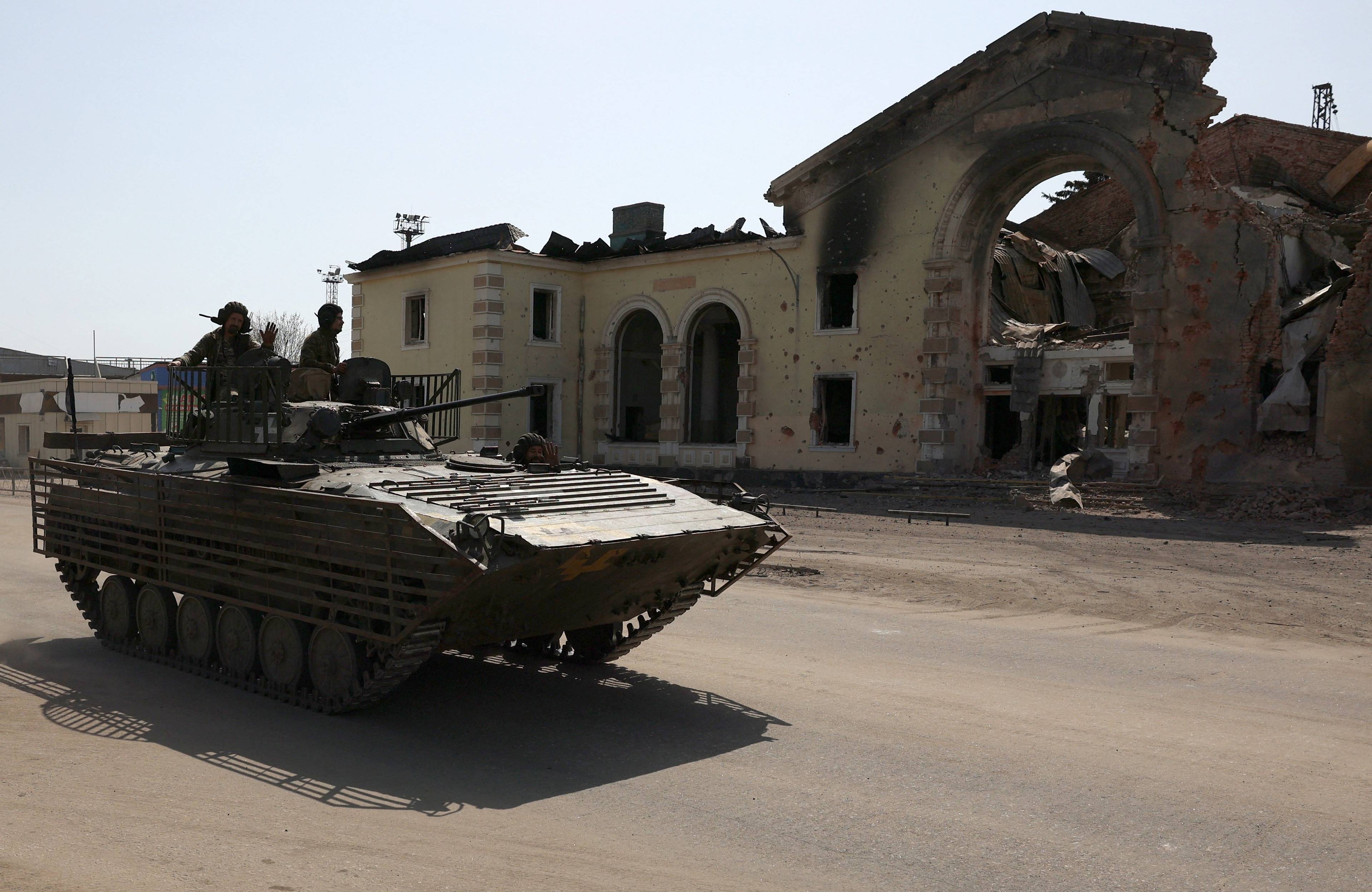 Bojowy wóz piechoty na tle zbombardowanego budynku