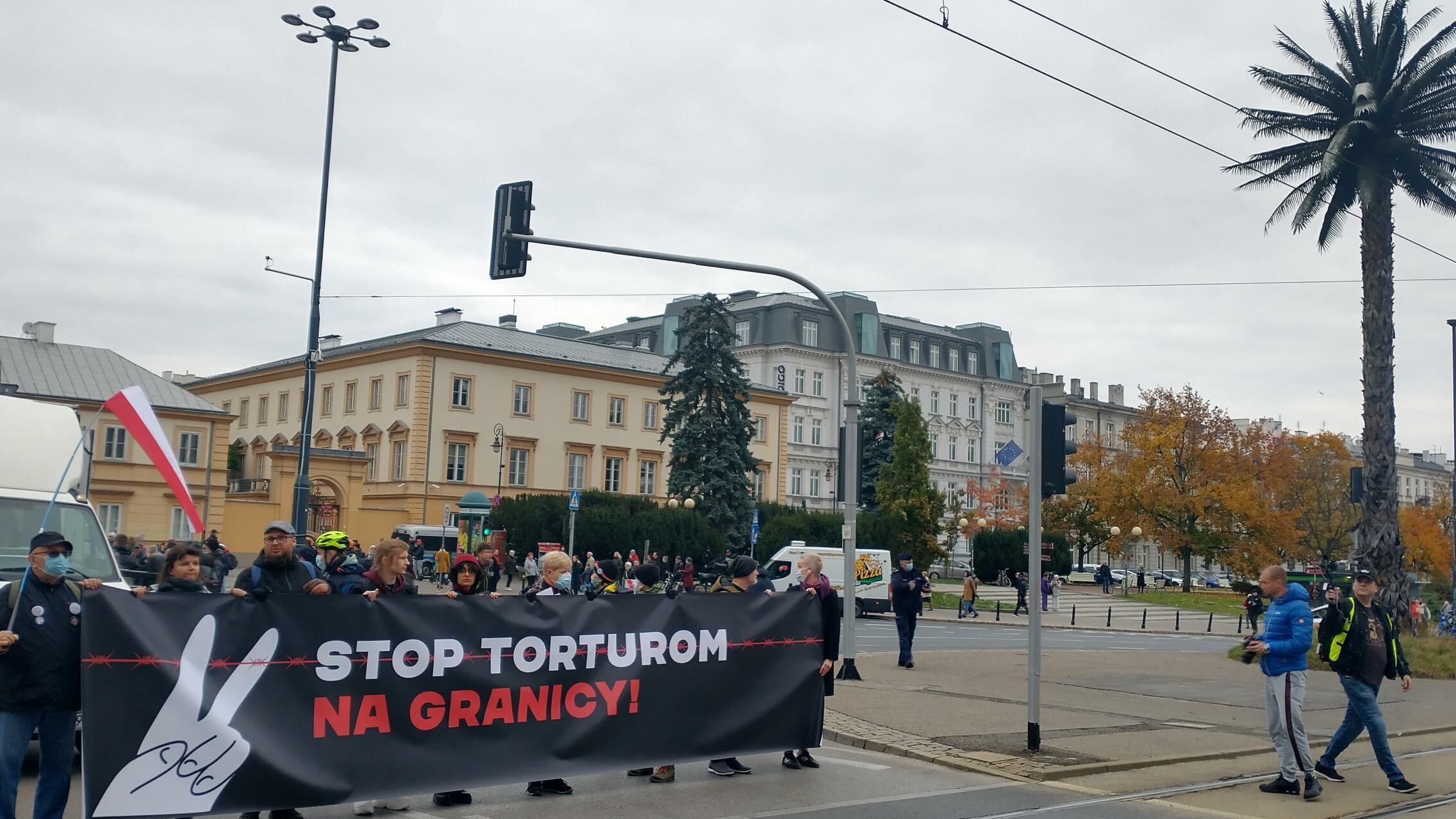 Warszawa. Protest przeciwko działaniom władz na granicy białoruskiej: manifestanci na rondzie De Gaulla z banerem „Stop torturom na granicy"