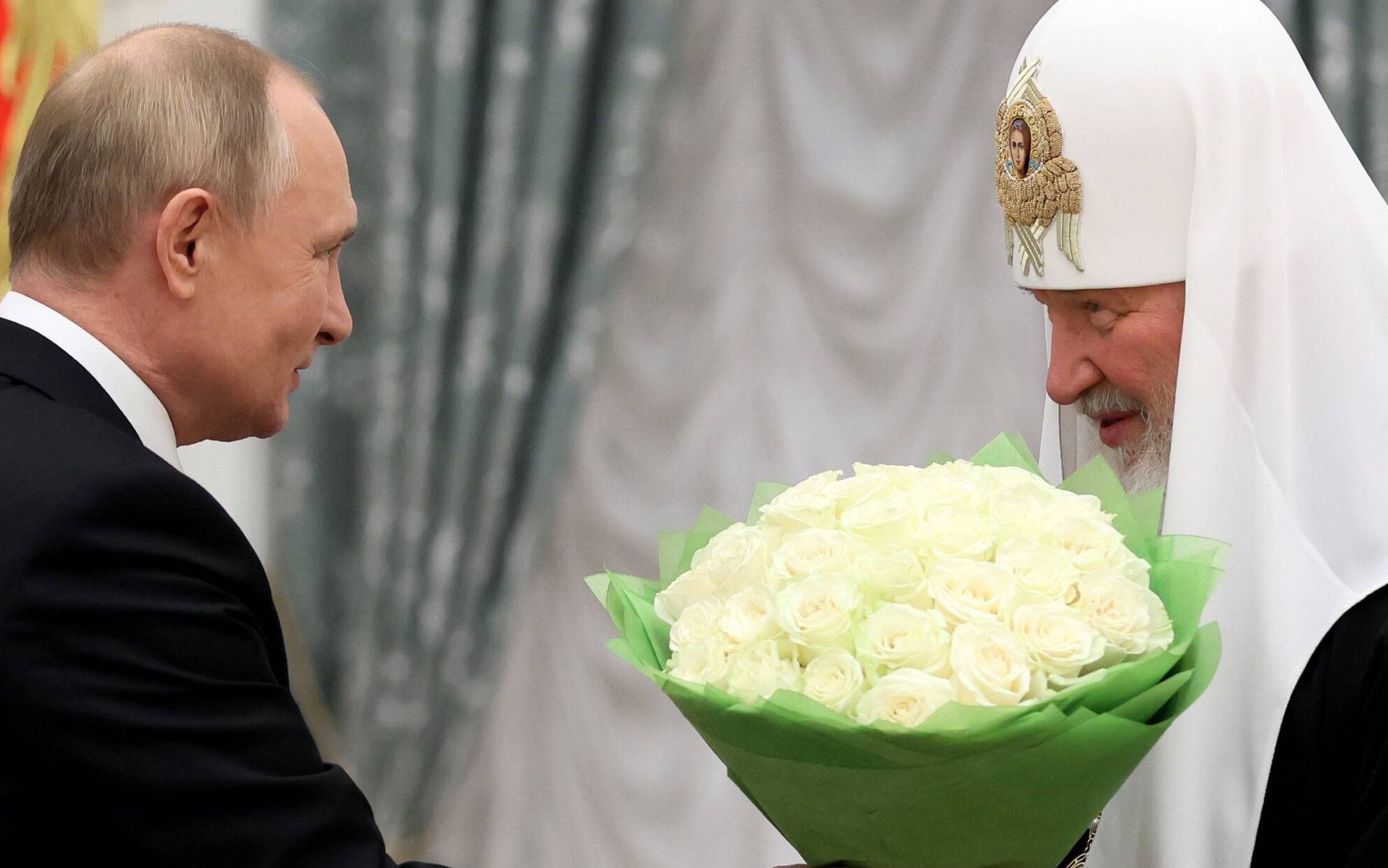 Russia's President Vladimir Putin (L) congratulates Patriarch Kirill of Moscow and All Russia during a presentation ceremony for presenting Andrew the First-Called order in Moscow on November 20, 2021. (Photo by Mikhail Metzel / SPUTNIK / AFP)