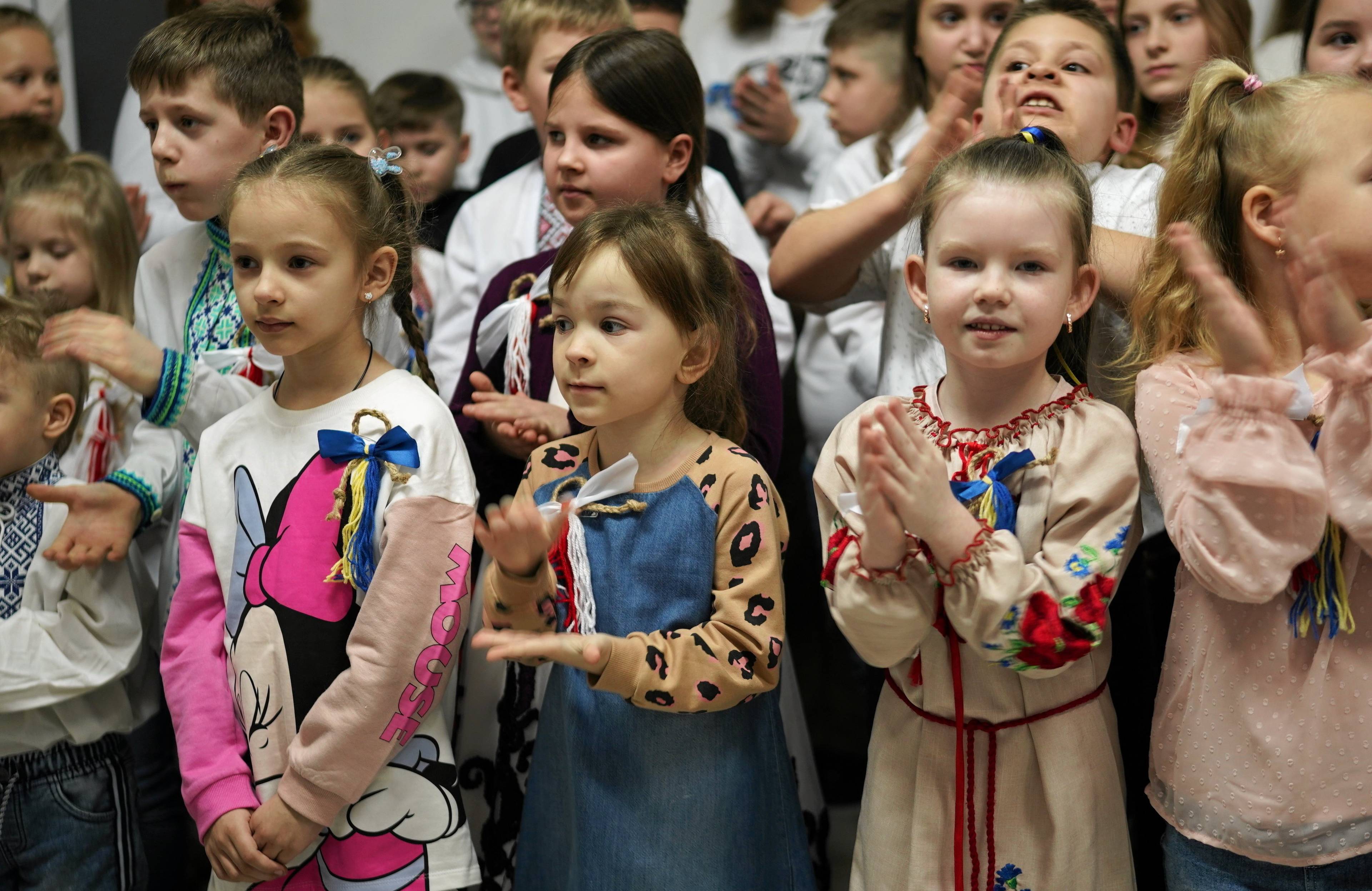 Na zdjęciu widać dzieci ukraińskie w wieku 6-10 lat. Niektóre z nich są w tradycyjnych koszulach wyszywanych