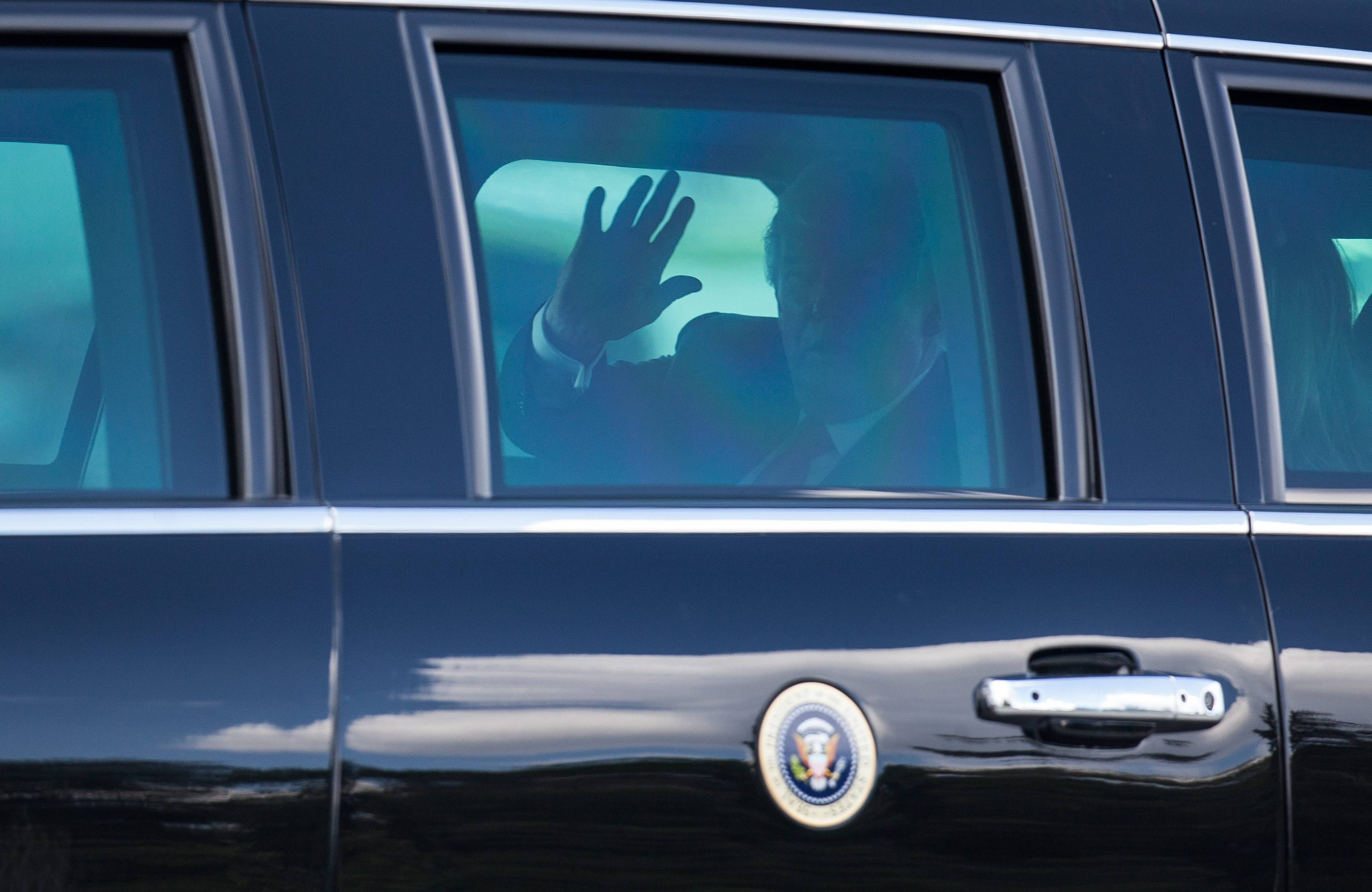 postać wewnątrz limuzyny z godłem prezydenckim USA