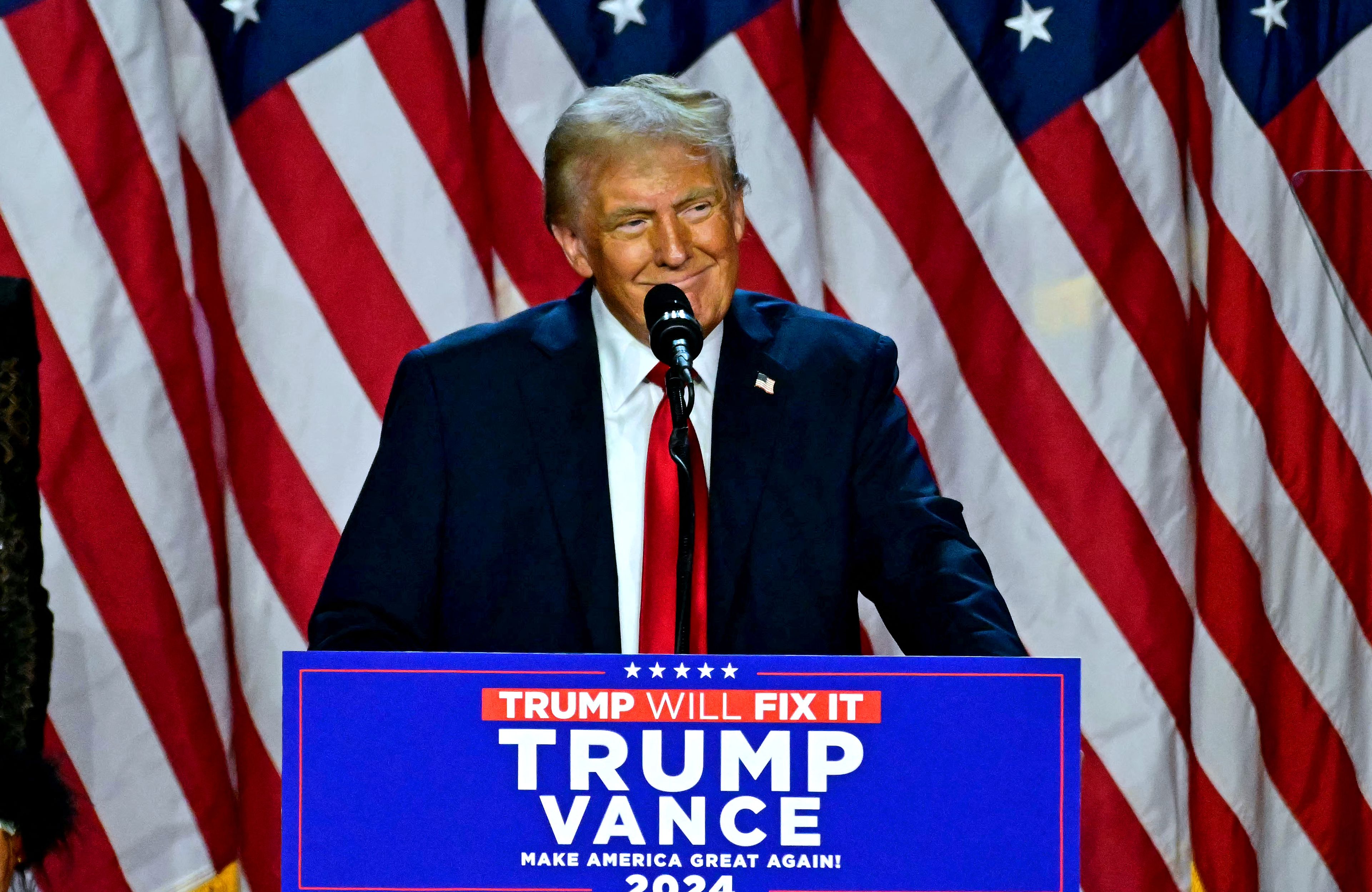 donald trump uśmiechnięty przy mównicy