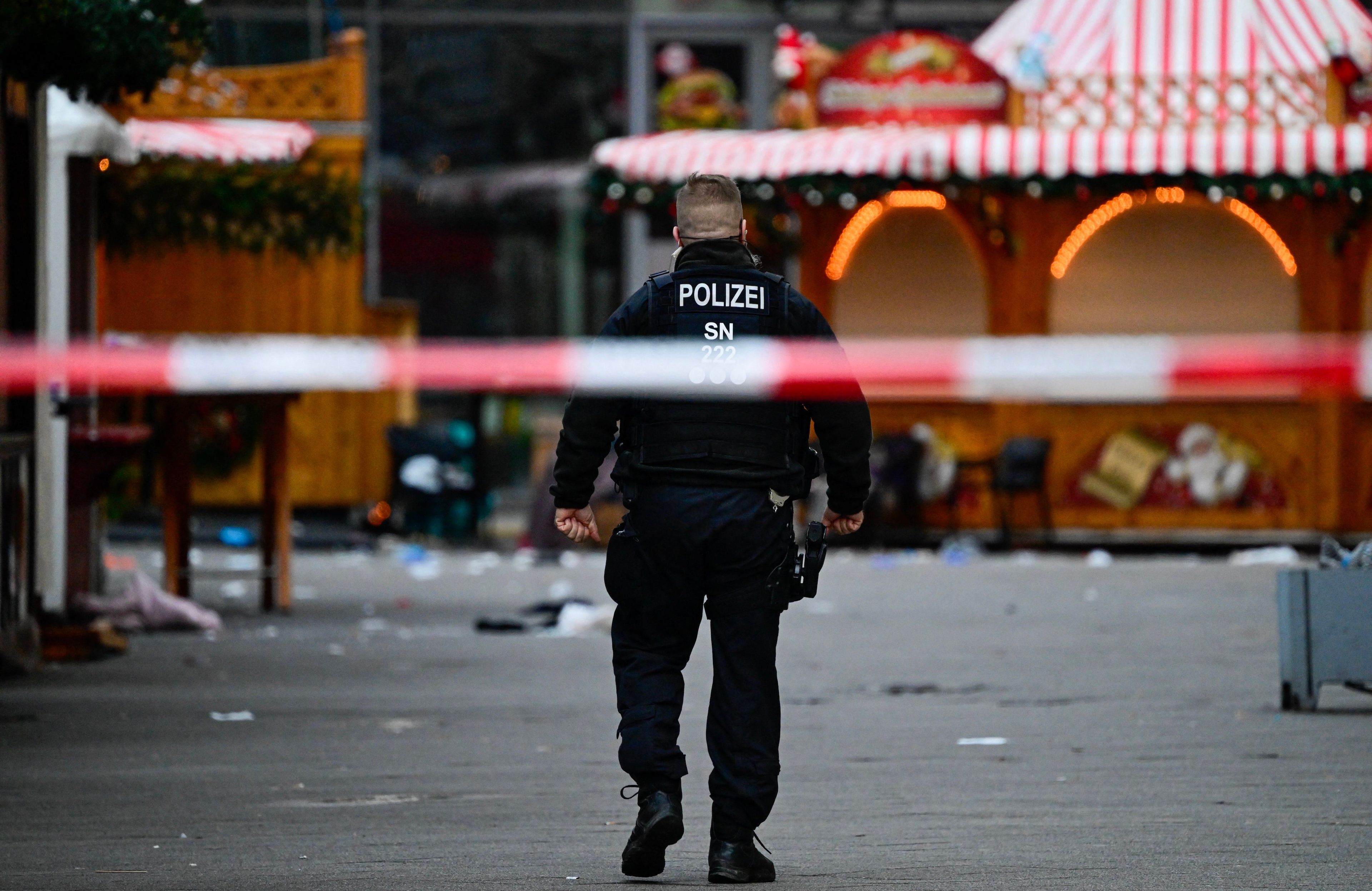 Policjant przechadza się po pustym i zamkniętym jarmarku