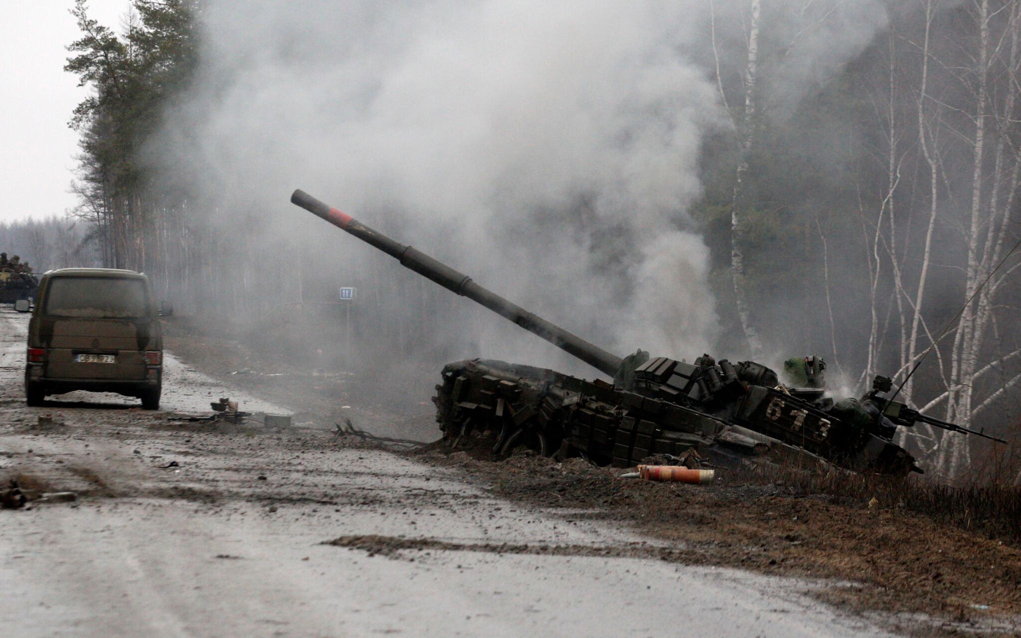 Smoke rises from a Russian tank destroyed by the Ukrainian forces on the side of a road in Lugansk region on February 26, 2022. - Russia on February 26 ordered its troops to advance in Ukraine "from all directions" as the Ukrainian capital Kyiv imposed a blanket curfew and officials reported 198 civilian deaths. (Photo by Anatolii Stepanov / AFP)