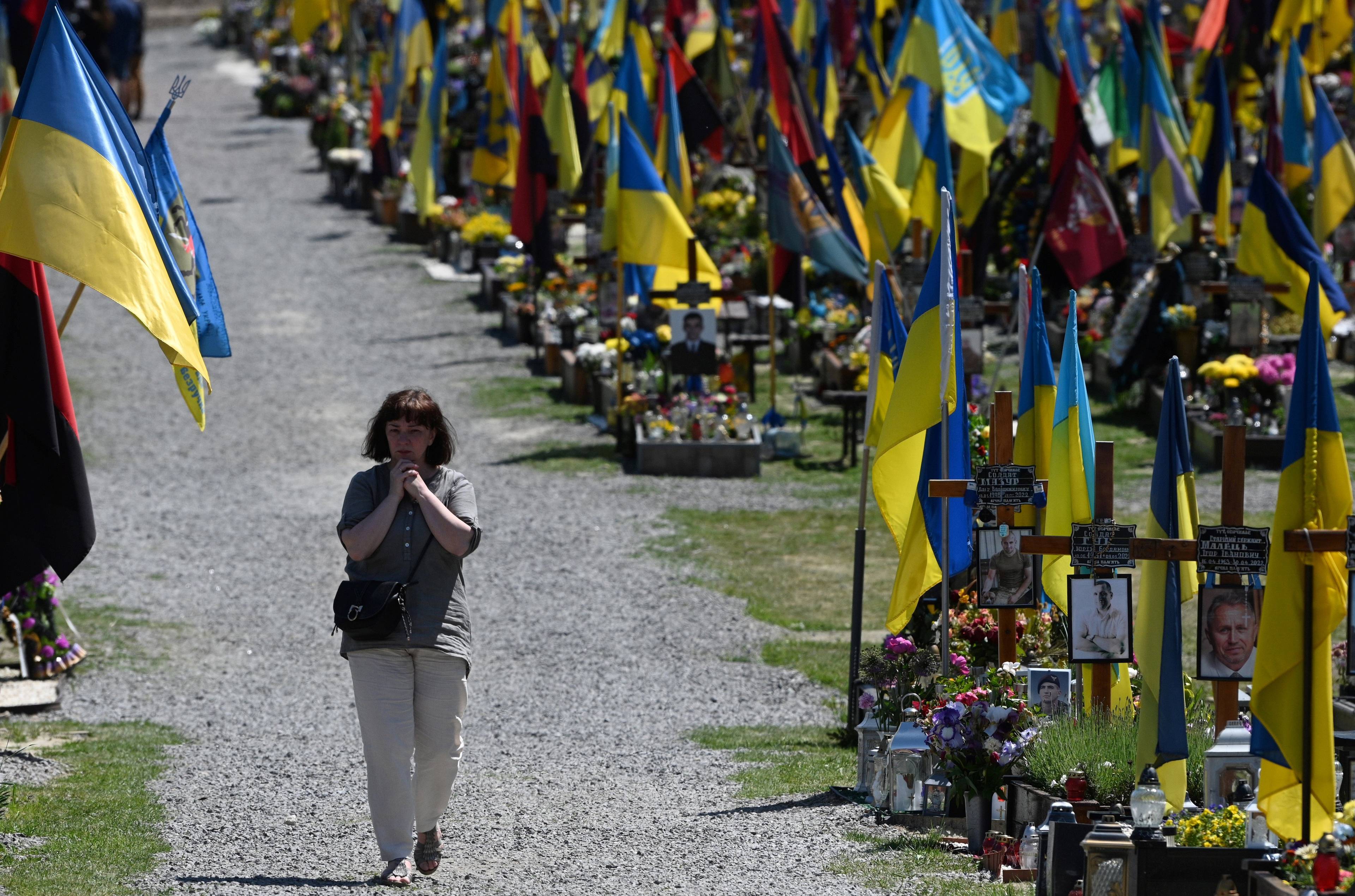 cmentarz żołnierzy ukraińskich, miedzy mogiłami, główną aleją idzie kobieta