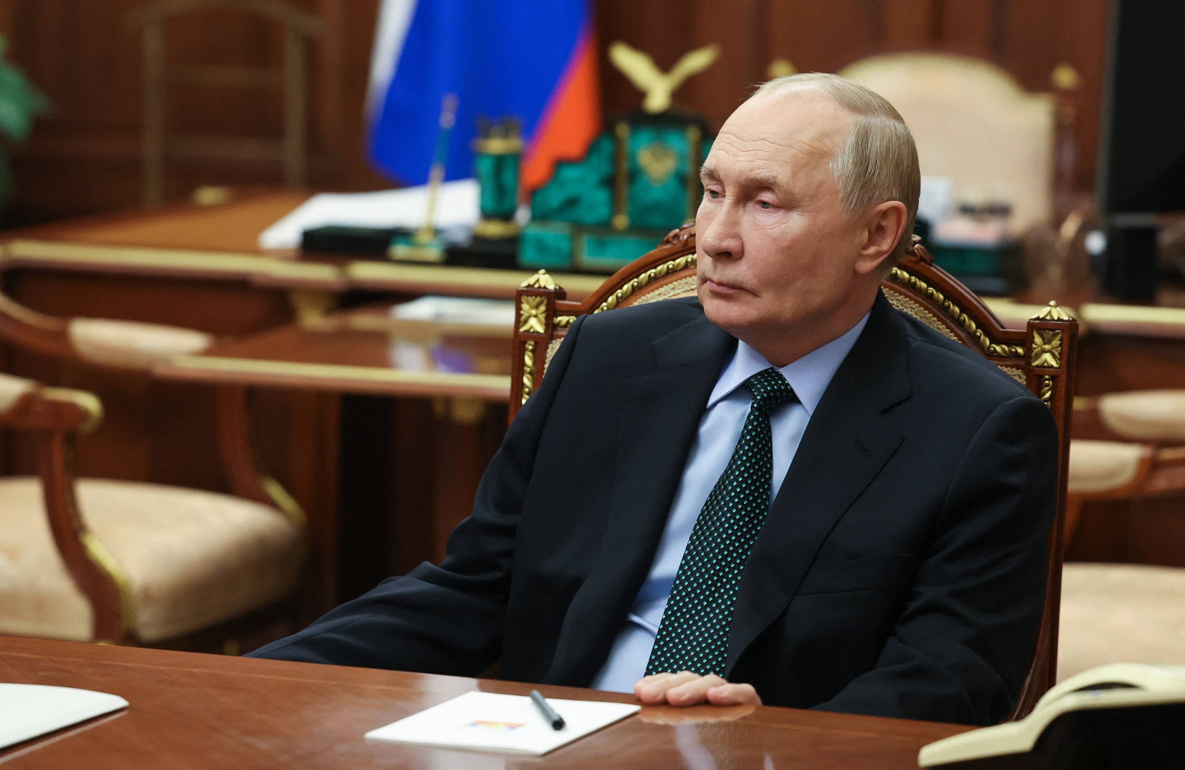 Władymir Putin siedzi przy biurku