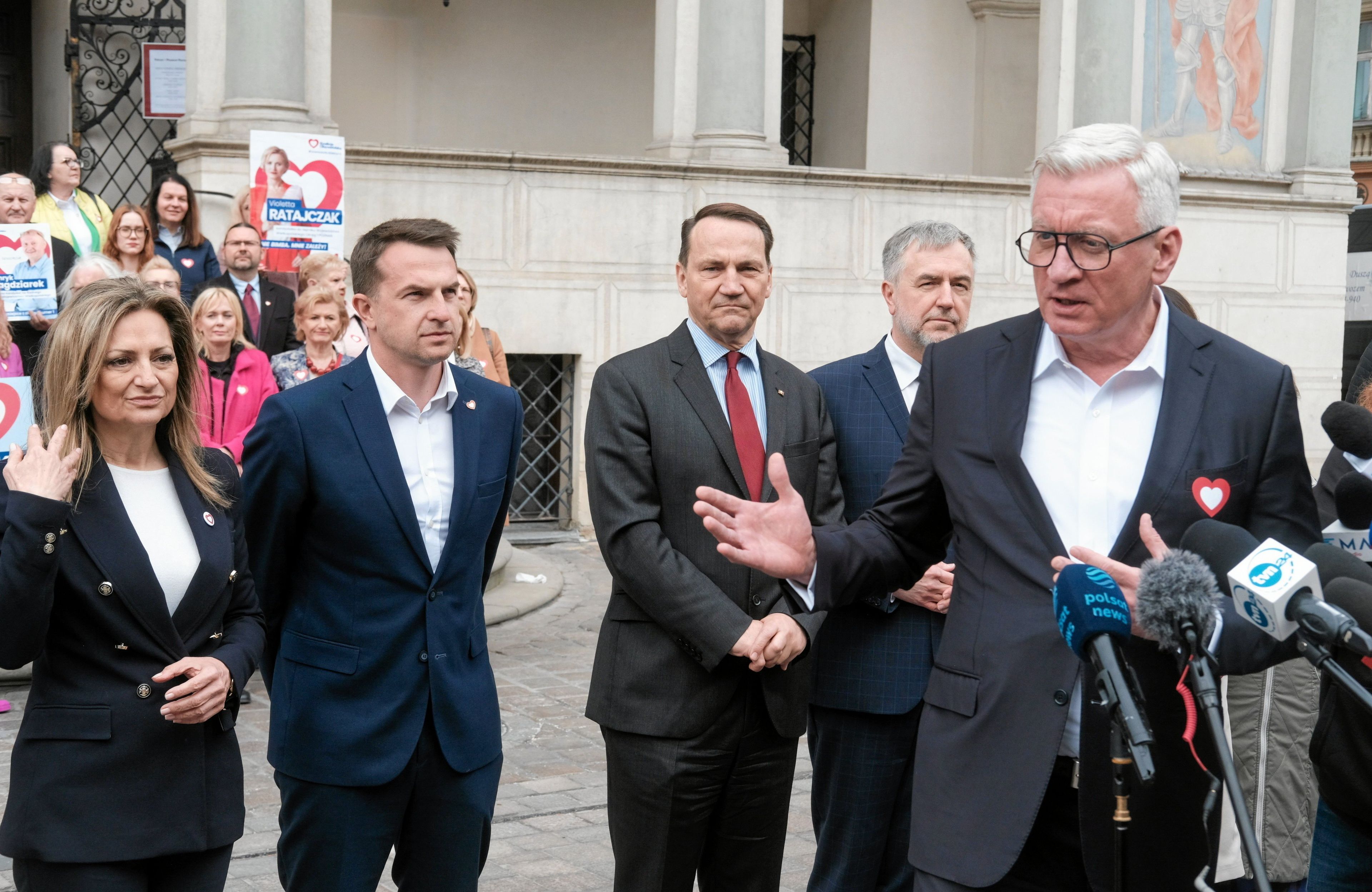 Jacek Jaśkowiak przemawia do mikrofonu na rynku poznańskim, w tle między innymi minister Radosław Sikorski