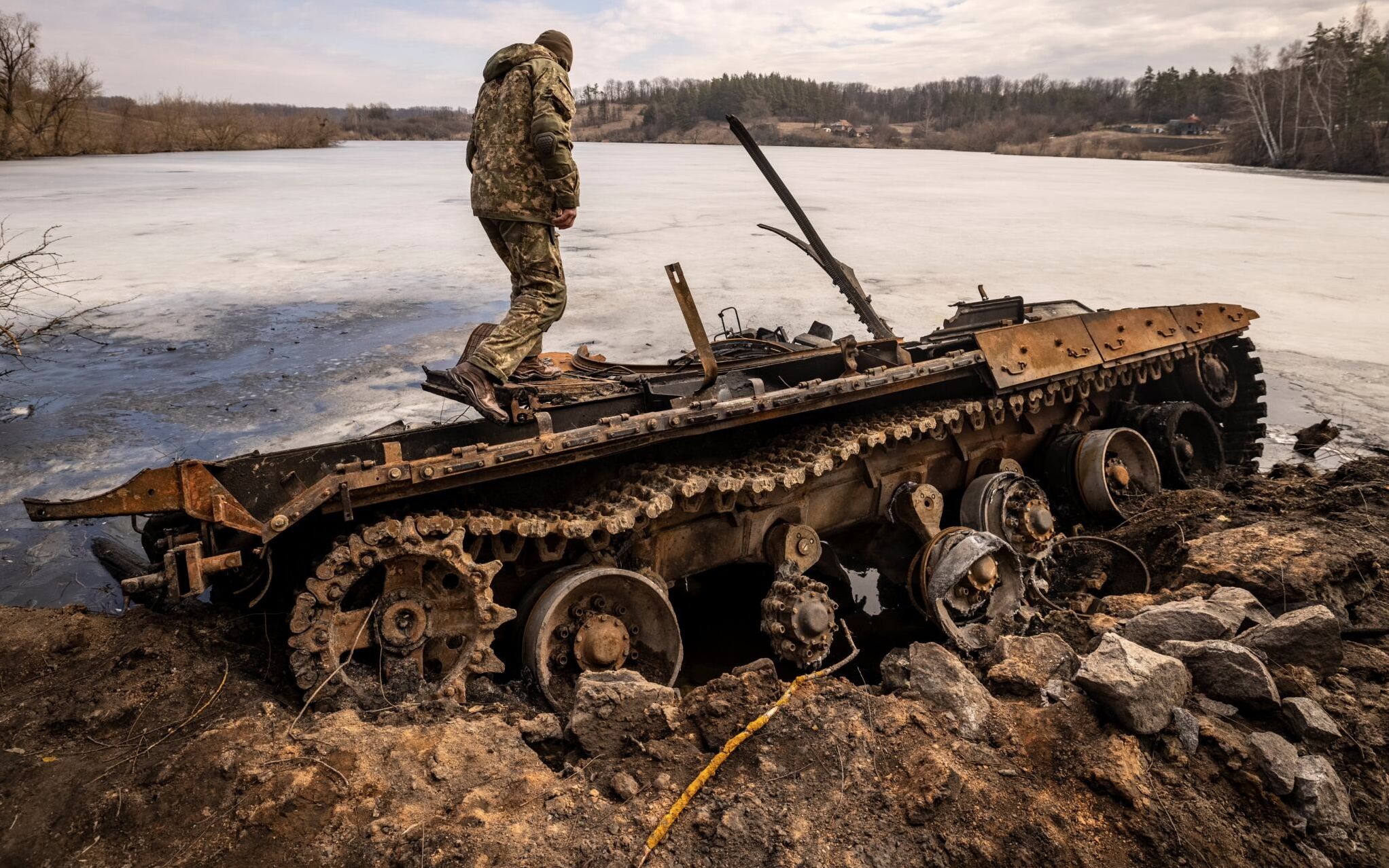A Ukrainian serviceman stands near a destroyed Russian tank in the northeastern city of Trostianets, on March 29, 2022. - Ukraine said on March 26, 2022 its forces had recaptured the town of Trostianets, near the Russian border, one of the first towns to fall under Moscow's control in its month-long invasion. (Photo by FADEL SENNA / AFP)