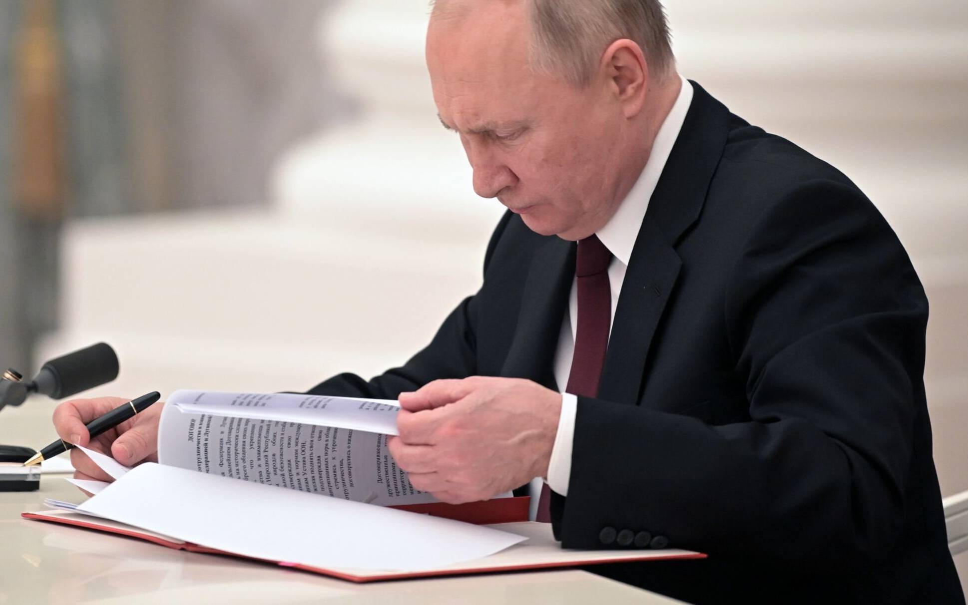 Russian President Vladimir Putin signs documents, including a decree recognising two Russian-backed breakaway regions in eastern Ukraine as independent, during a ceremony at the Kremlin in Moscow on February 21, 2022. - President Vladimir Putin said on February 21, 2022, he would make a decision "today" on recognising the independence of east Ukraine's rebel republics, after Russia's top officials made impassioned speeches in favour of the move. (Photo by Alexey NIKOLSKY / Sputnik / AFP)