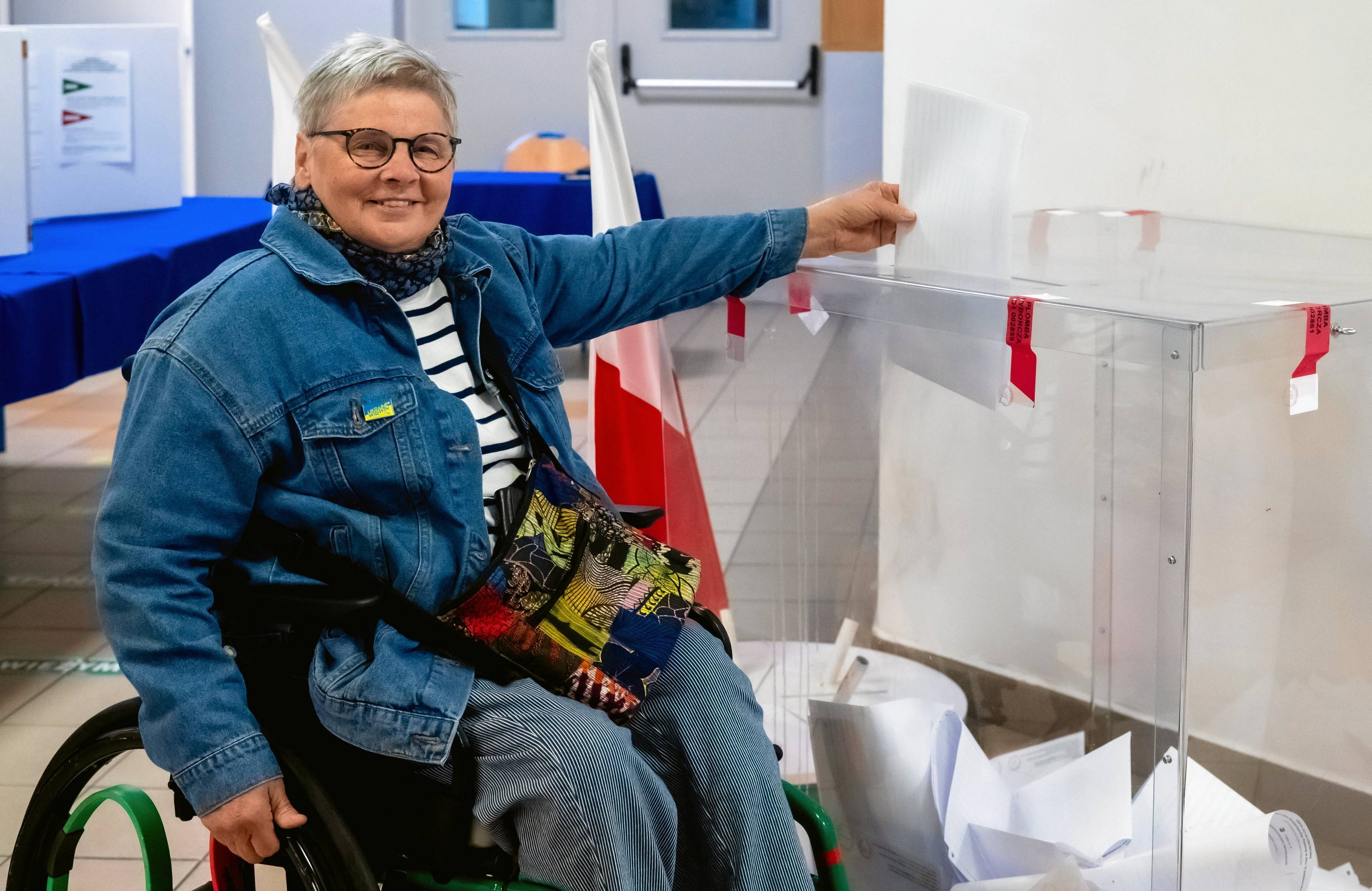 Janina Ochojska na wózku inwalidzkim wrzuca głos do urny, wybory samorządowe