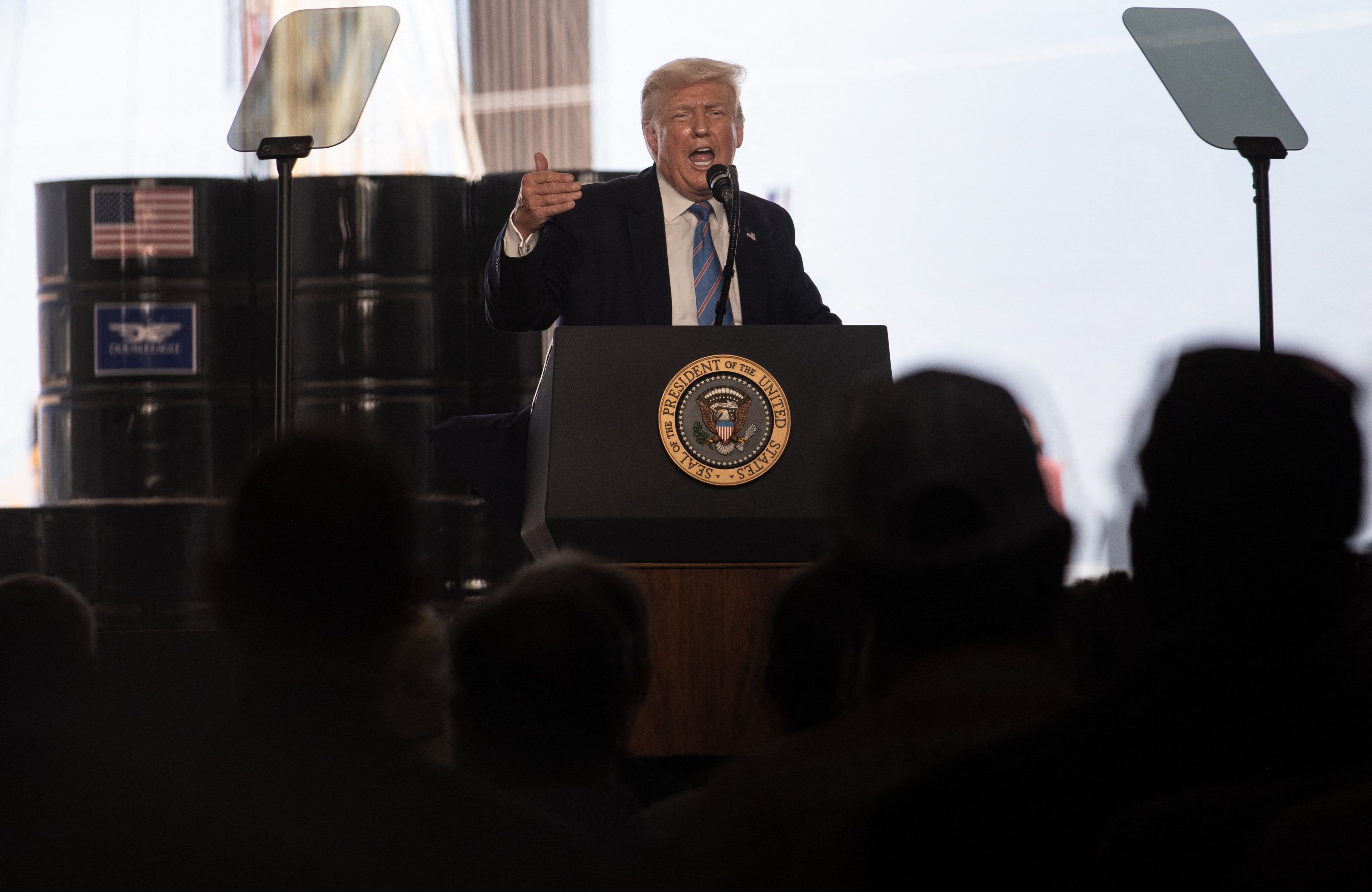 Donald Trum przemawia na tle beczek z ropą