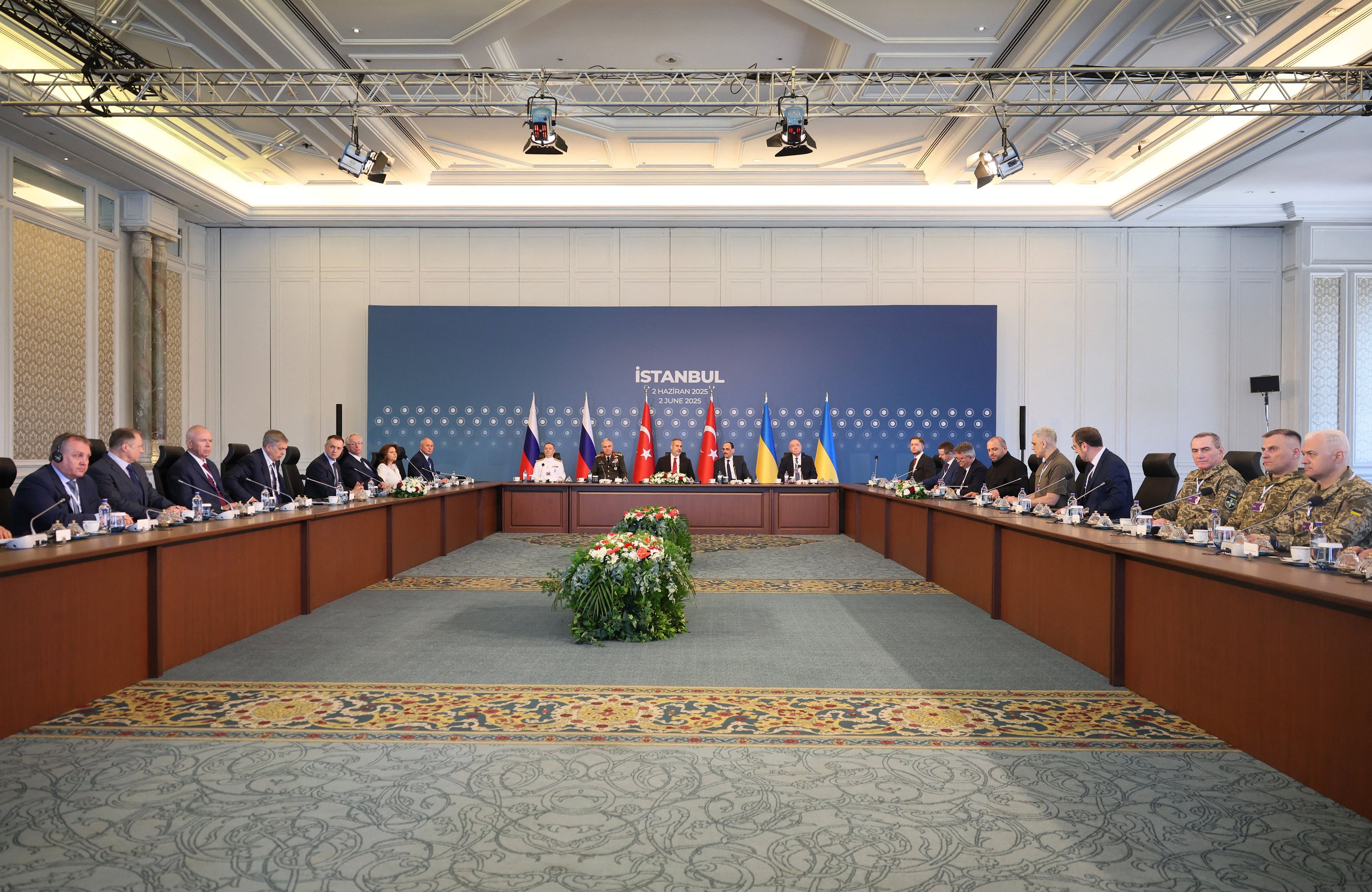 Członkowie delegacji ukraińskiej (R), rosyjskiej (L) i tureckiej (C) uczestniczą w drugim spotkaniu w Pałacu Ciragan w Stambule, 2 czerwca 2025 r. Delegacje Ukrainy i Rosji rozpoczęły drugą rundę rozmów pokojowych w Stambule, gdzie mają wymienić się planami zakończenia trzyletniej wojny.