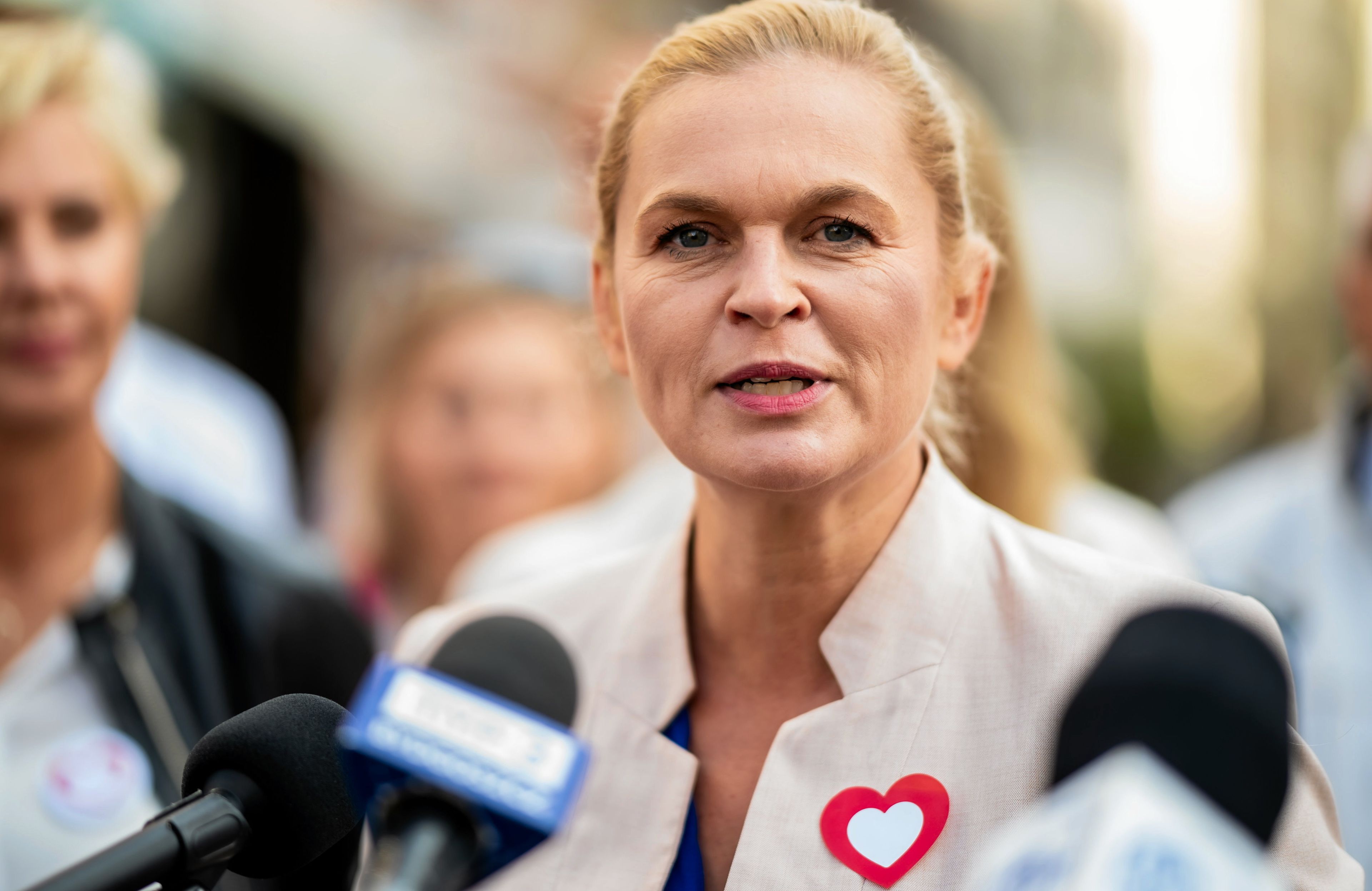 Barbara Nowacka rozmawia z dziennikarzami, w klapie serduszko-symbol Koalicji Obywatelskiej