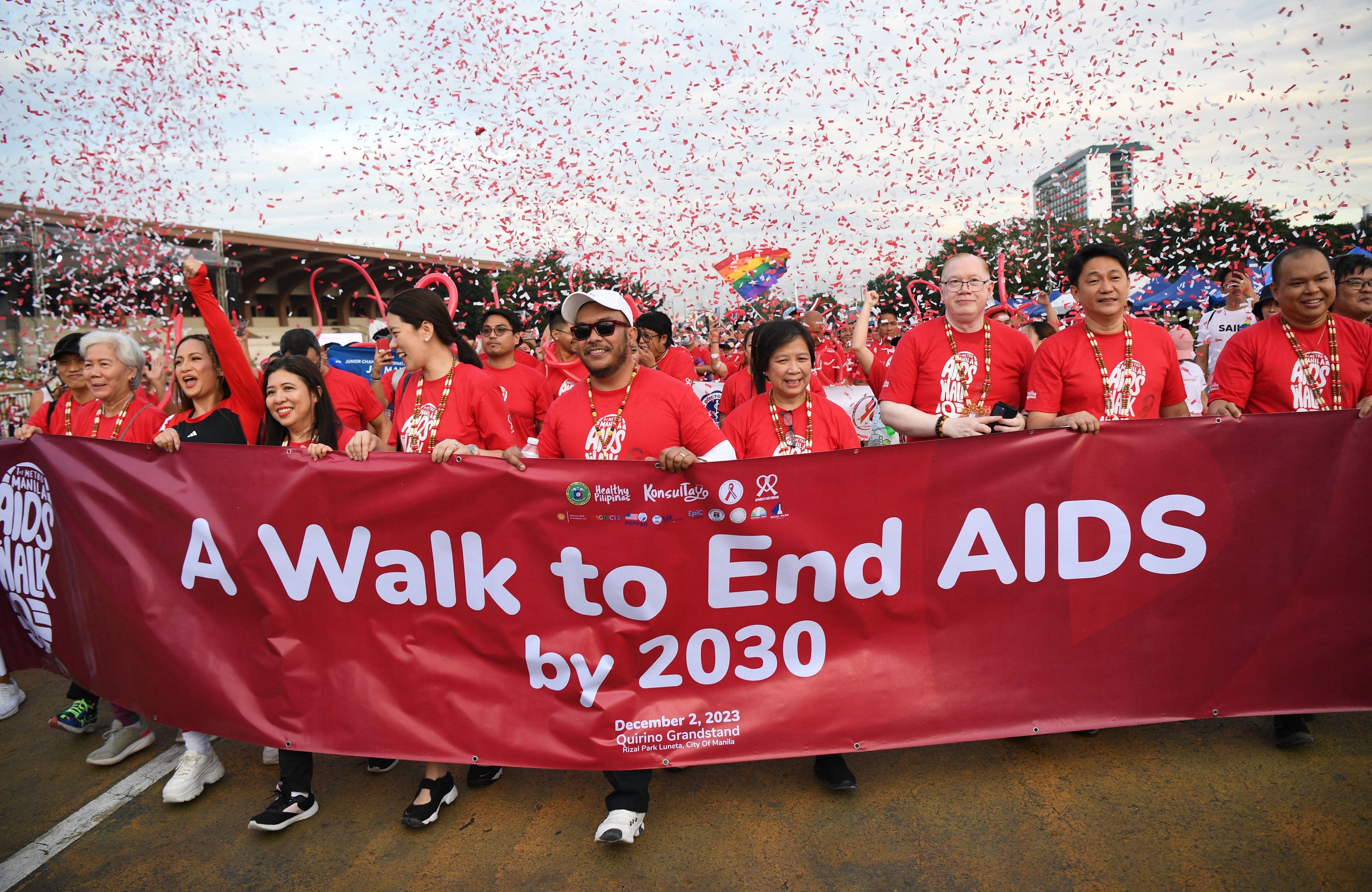 Czoło marszu trzyma baner z napisem "I walk to end AIDS by 2030"