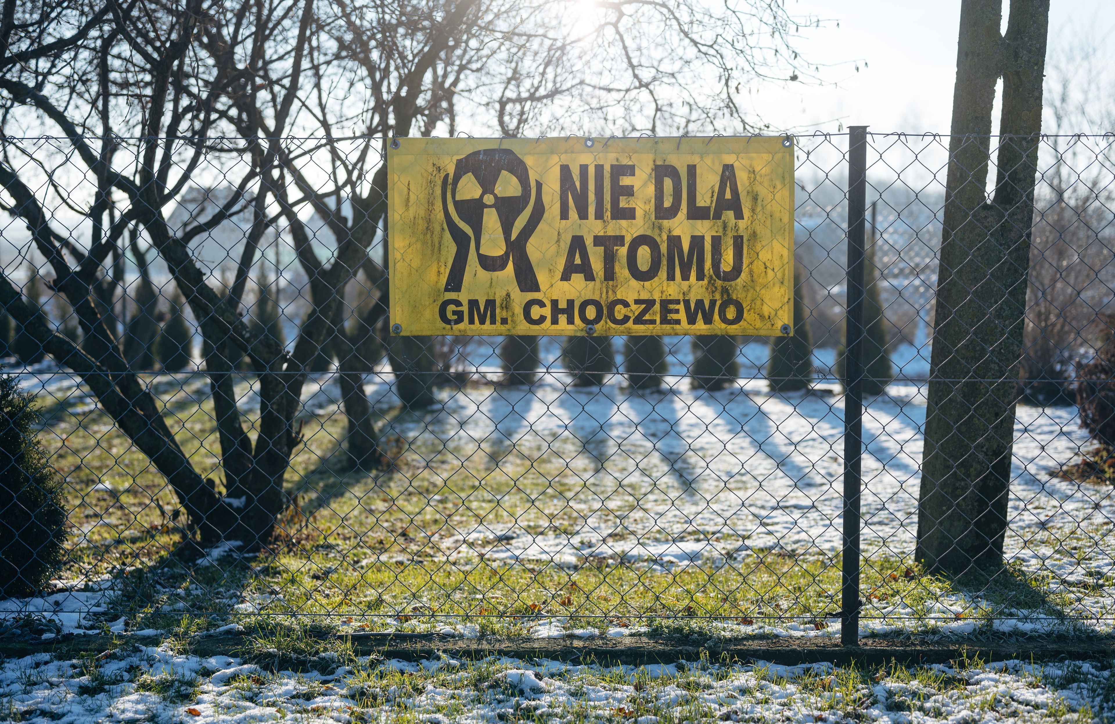 antyatomowy baner powieszony na ogrodzeniu w gminie Choczewo