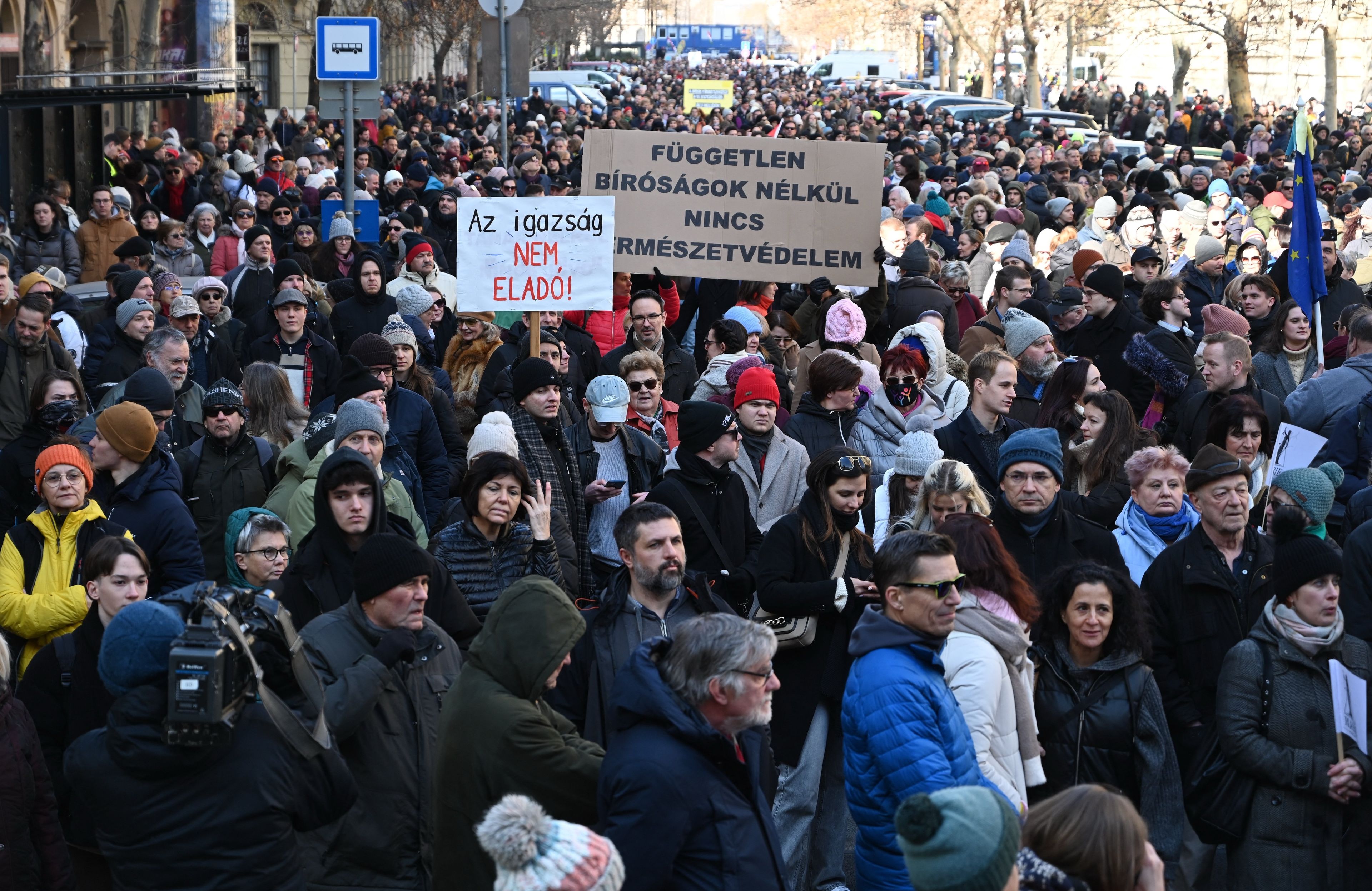 Tłum ludzi trzyma banery z napisami po węgiersku