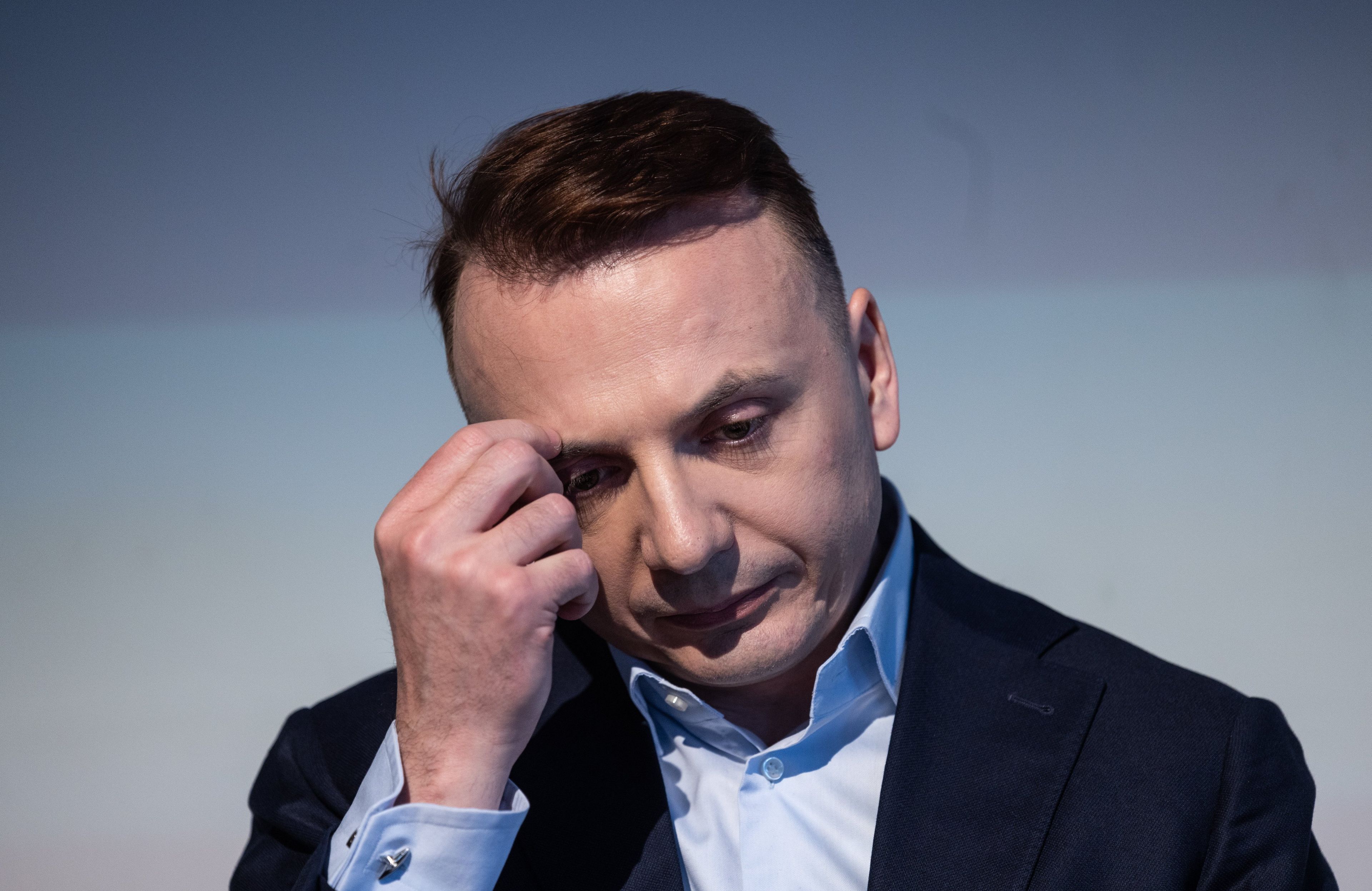 Łukasz Gibała podpiera twarz ręką