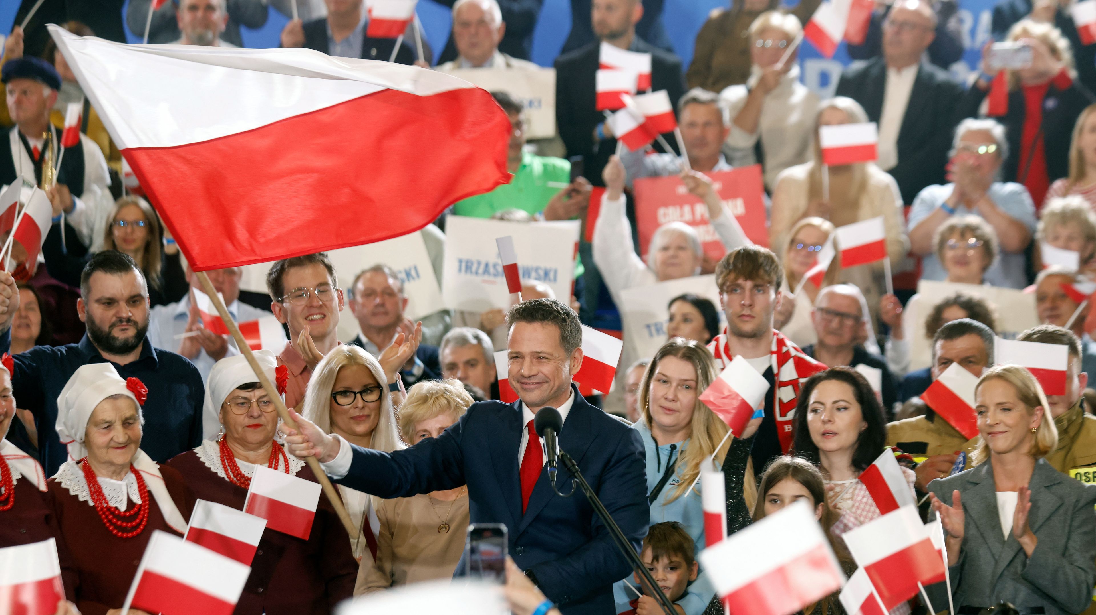 Rafał Trzaskowski macha flagą Polski na wiecu