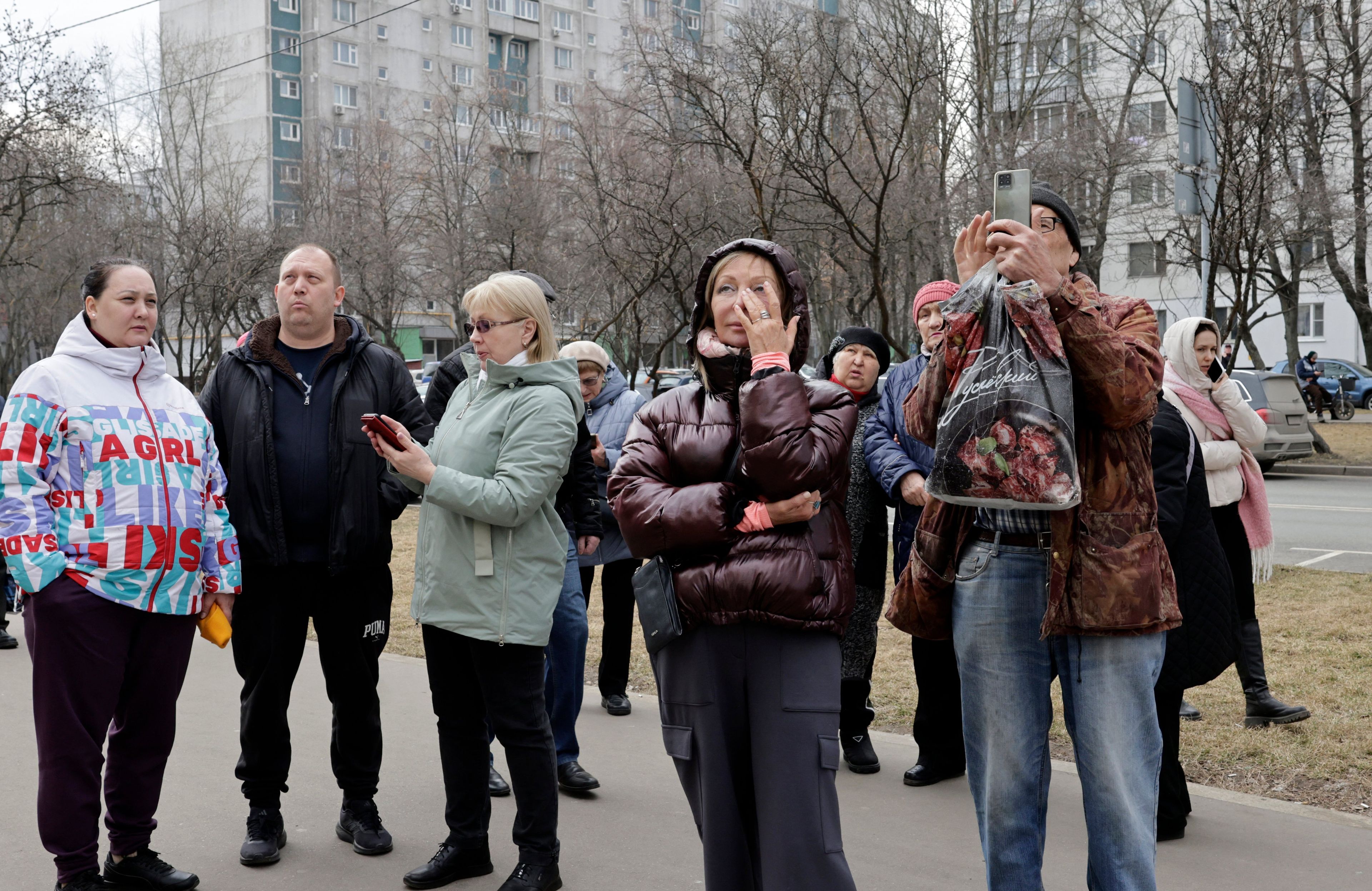 Mieszkańcy Moskwy przed blokiem uszkodzonym przez drony