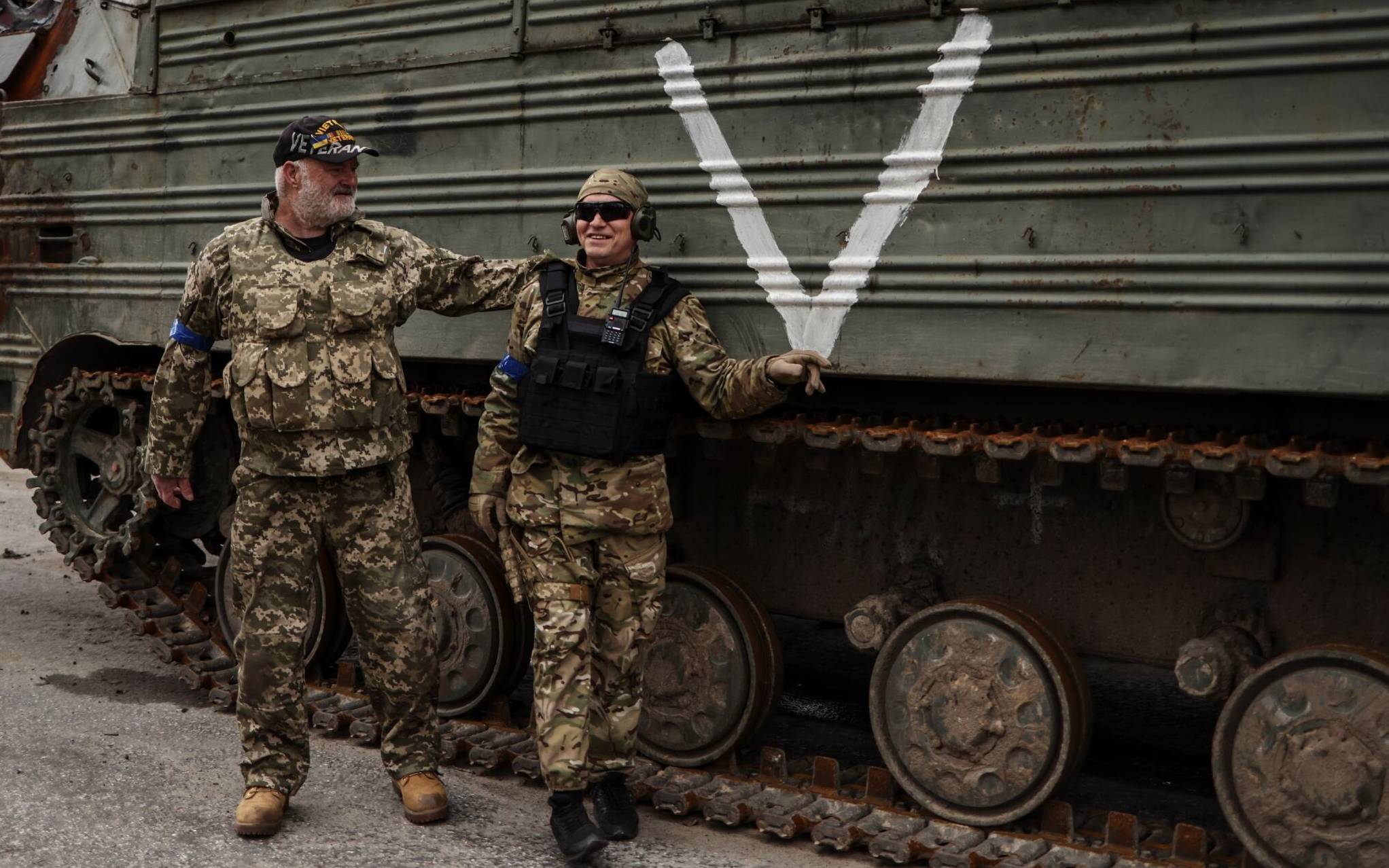 US war veteran Steven Straub (R) poses for a picture next to a member of Ukranian army as they patrol on a road near Buda-Babynetska, north of Kyiv, on April 5, 2022, days after Russian forces retreated from the area. (Photo by RONALDO SCHEMIDT / AFP)