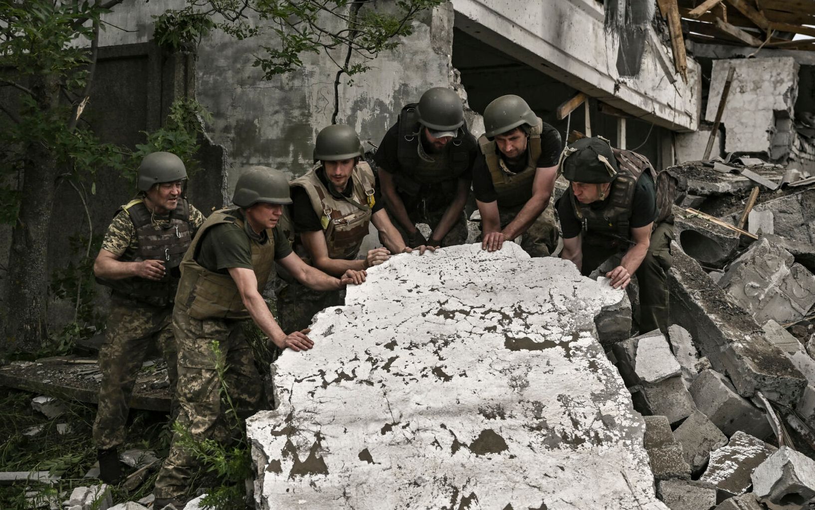 Ukrainian soldiers inspect a destroyed warehouse reportedly targeted by Russian troops on outskirts of Lysychansk, in the eastern Ukrainian region of Donbas on June 17, 2022, as the Russian-Ukraine war enters its 114th day. (Photo by ARIS MESSINIS / AFP)