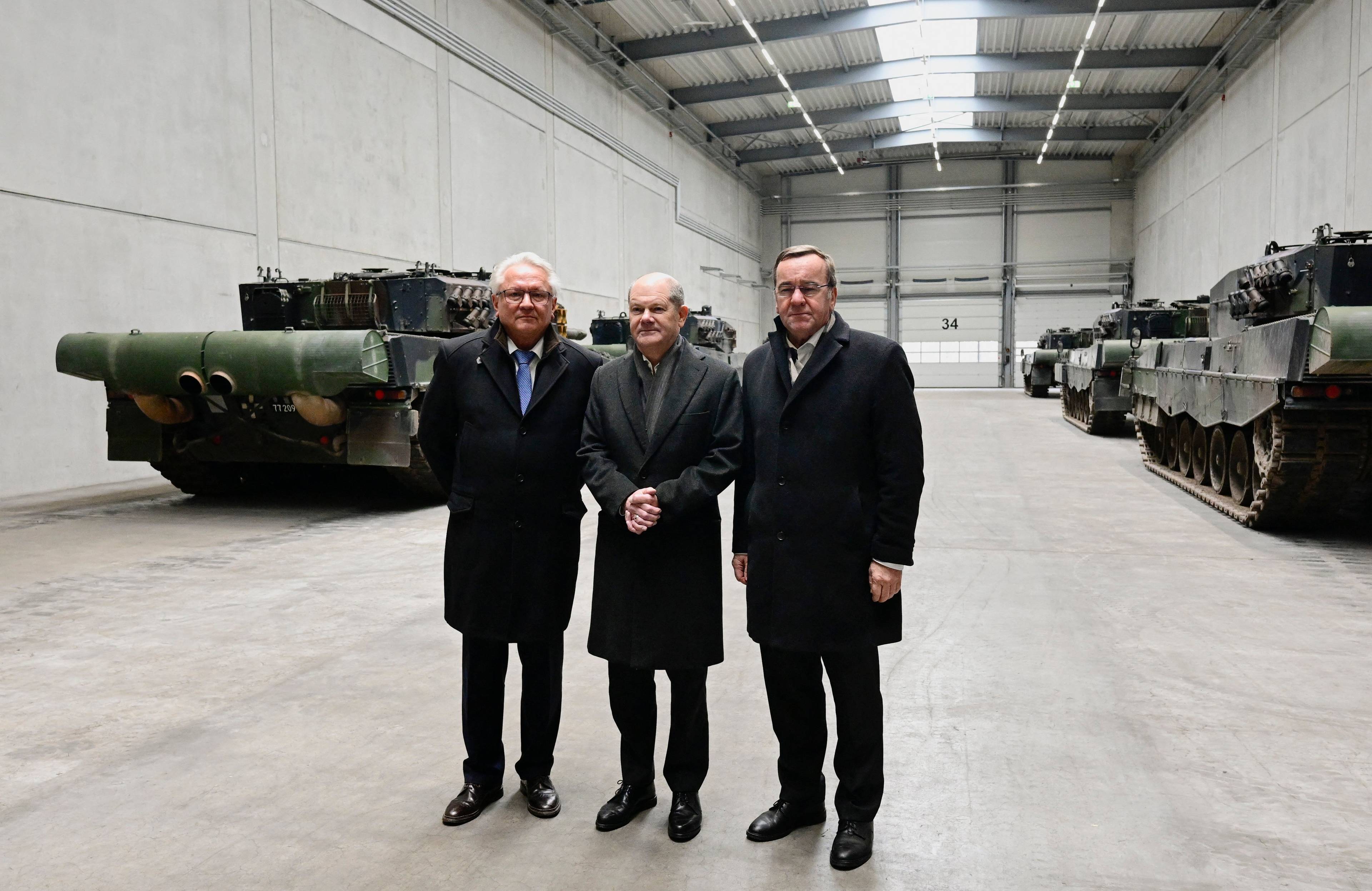 Od lewej: CEO Rheinmetall Armin Papperger, kanclerz Niemiec Olaf Scholz i niemiecki minister obrony Boris Pistorius na tle Leopardów