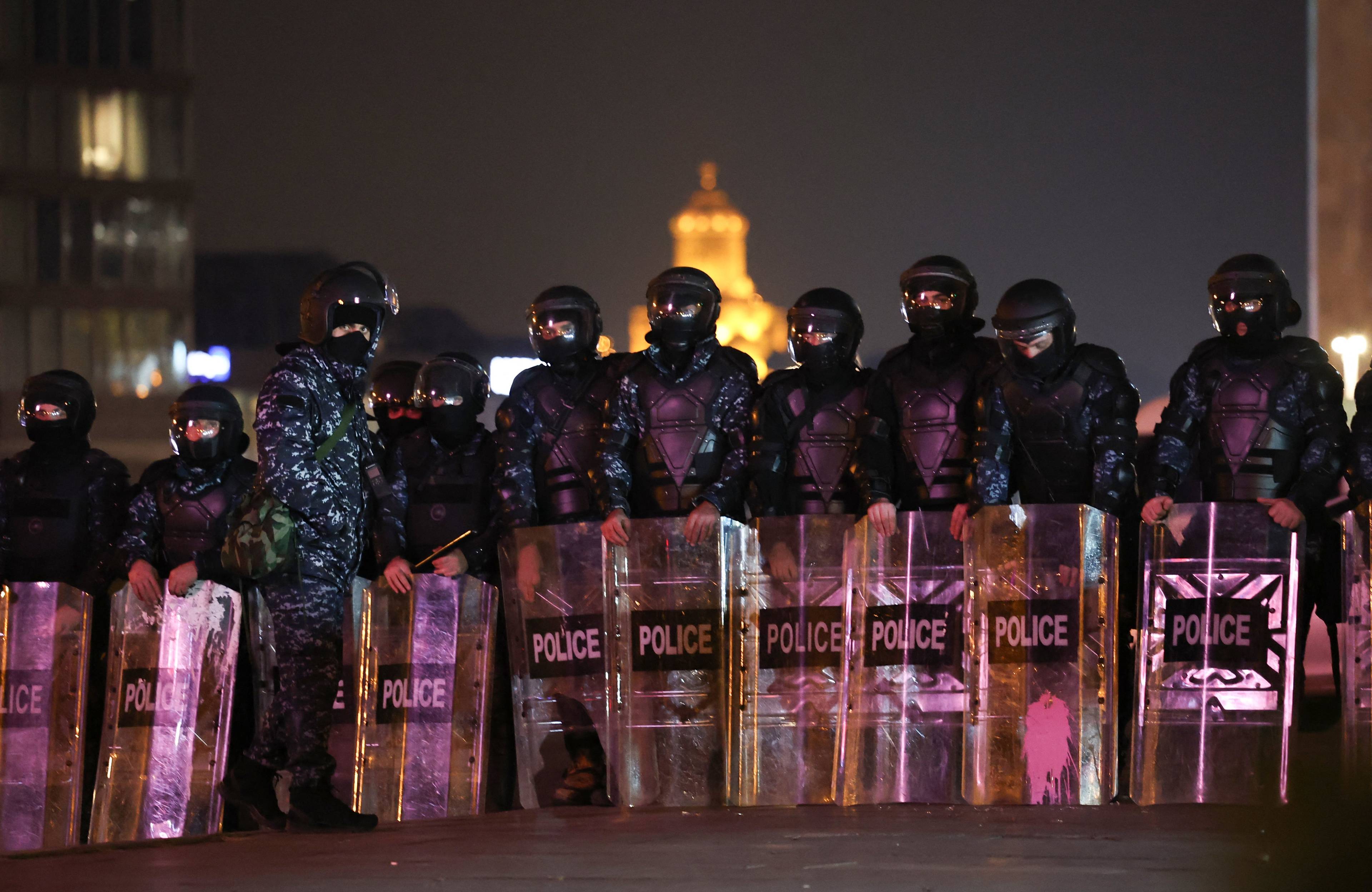 Noc. Rząd zamaskowanych policjantów z tarczami