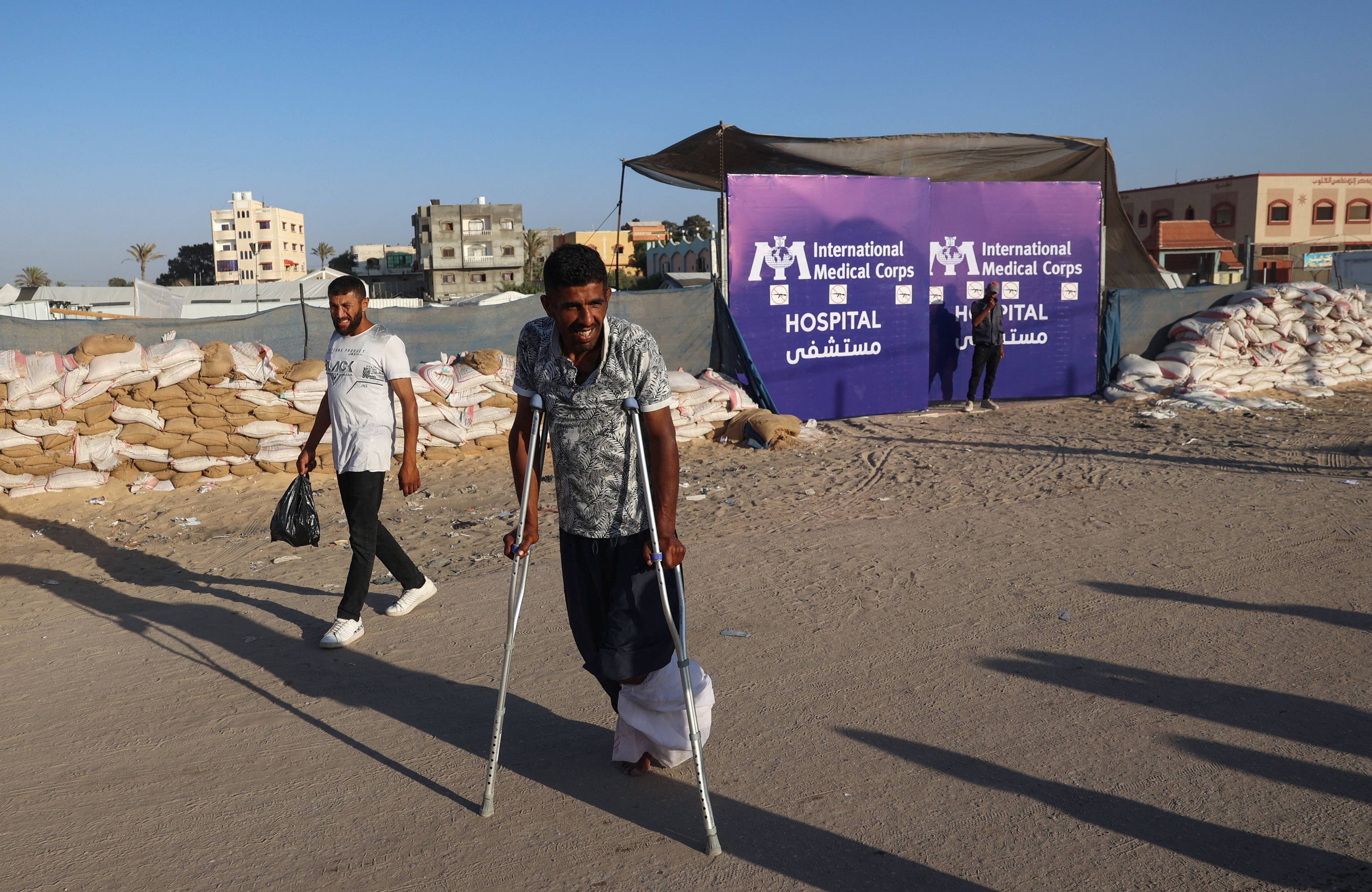 Mężczyzna w Rafah z opatrzoną nogą porusza się o kulach