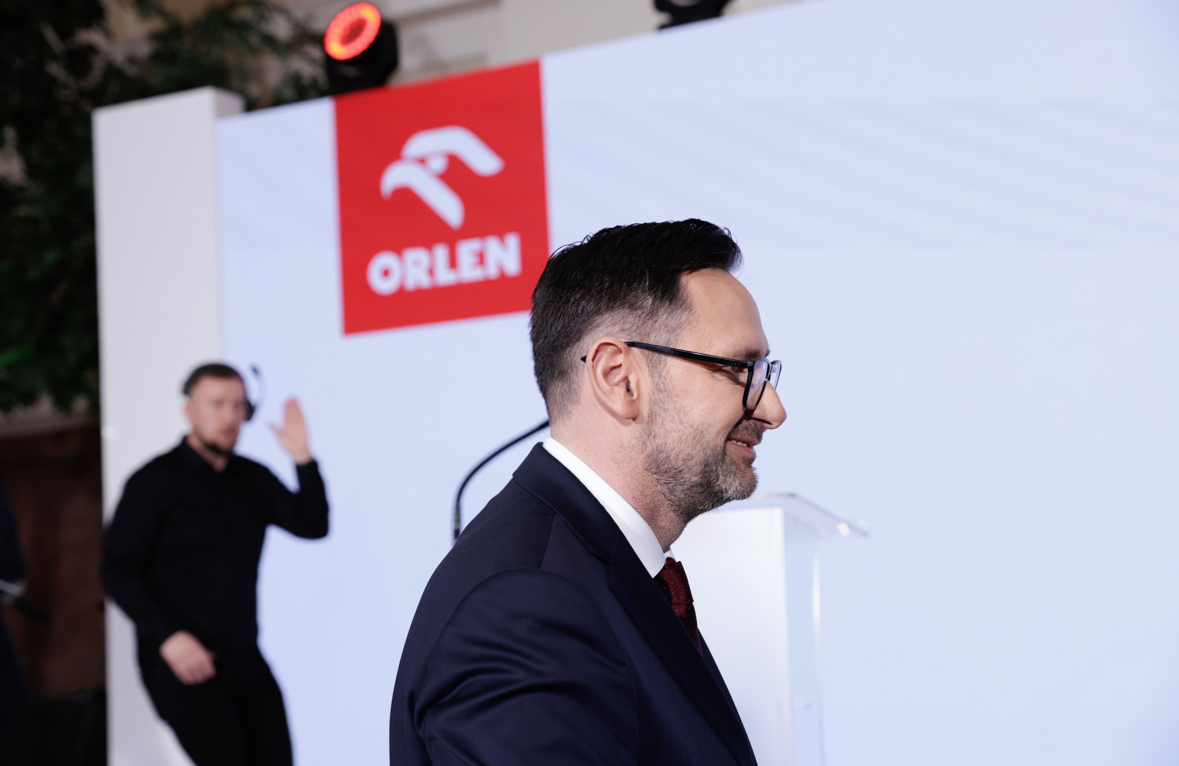 Donald Obajtek z profilu na tle loga Orlenu