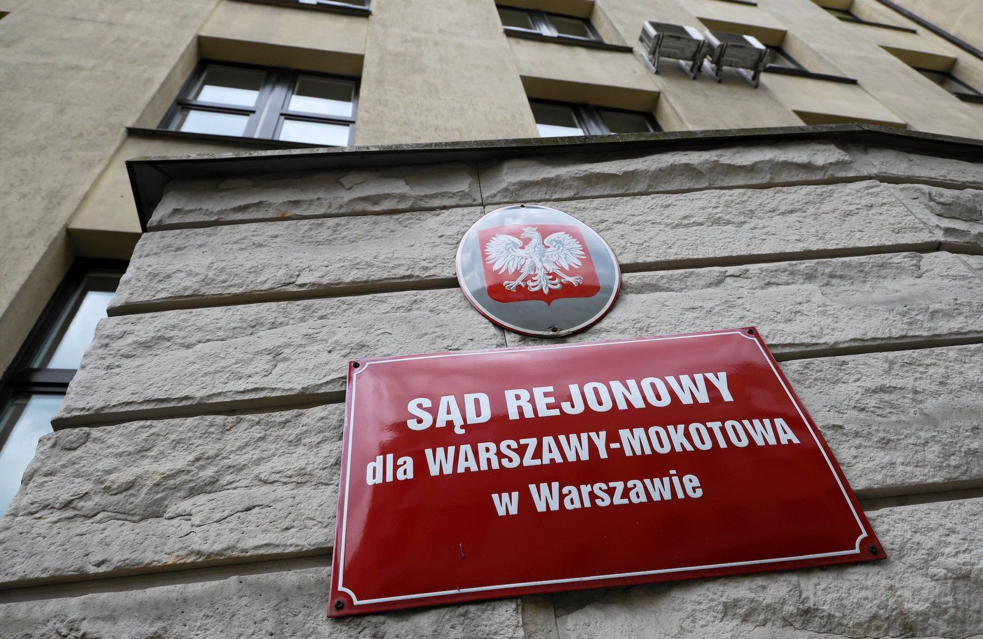 Budynek Sądu Rejonowego dla Warszawy-Mokotowa. Na pierwszym planie tabliczka z nazwą sądu i godłem.