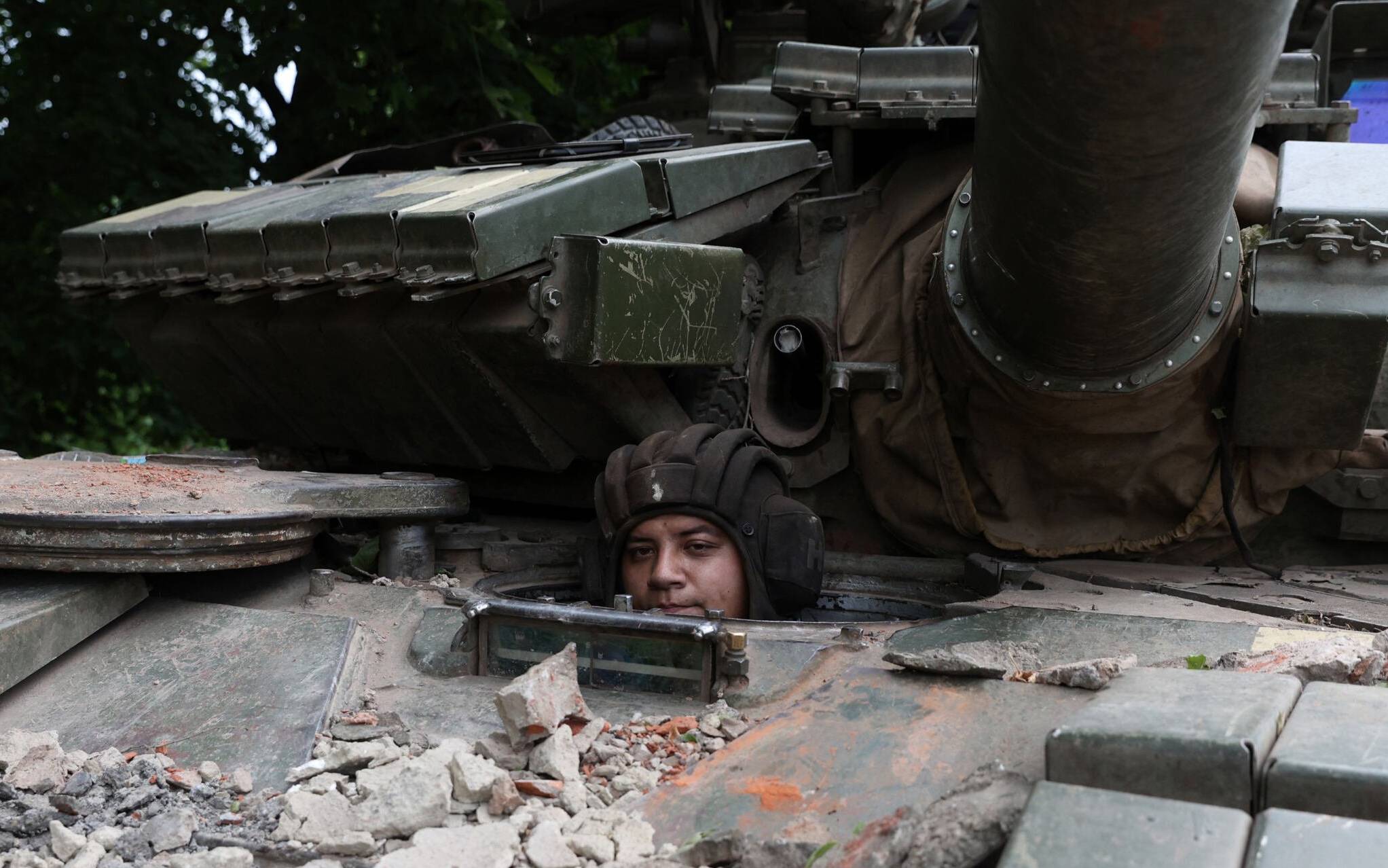 A Ukrainian serviceman peers out from a tank at a front line position near Kostyantynivka, Donetsk region on June 18, 2022, amid the Russian invasion of Ukraine. (Photo by Anatolii STEPANOV / AFP)