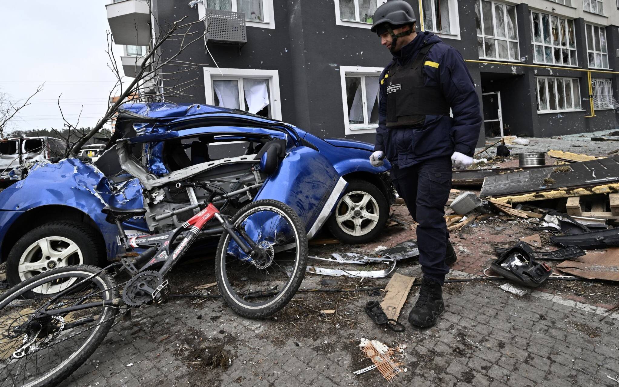 A field engineer of the State Emergency Service of Ukraine checks a damaged residential area in Bucha on April 5, 2022, as Ukrainian officials say over 400 civilian bodies have been recovered from the wider Kyiv region, many of which were buried in mass graves. - Bucha had been occupied by Russian troops, but when they withdrew recently Ukrainian authorities and independent international journalists including AFP found bodies of people in civilian clothing, some with their hands tied behind their backs. (Photo by Genya SAVILOV / AFP)